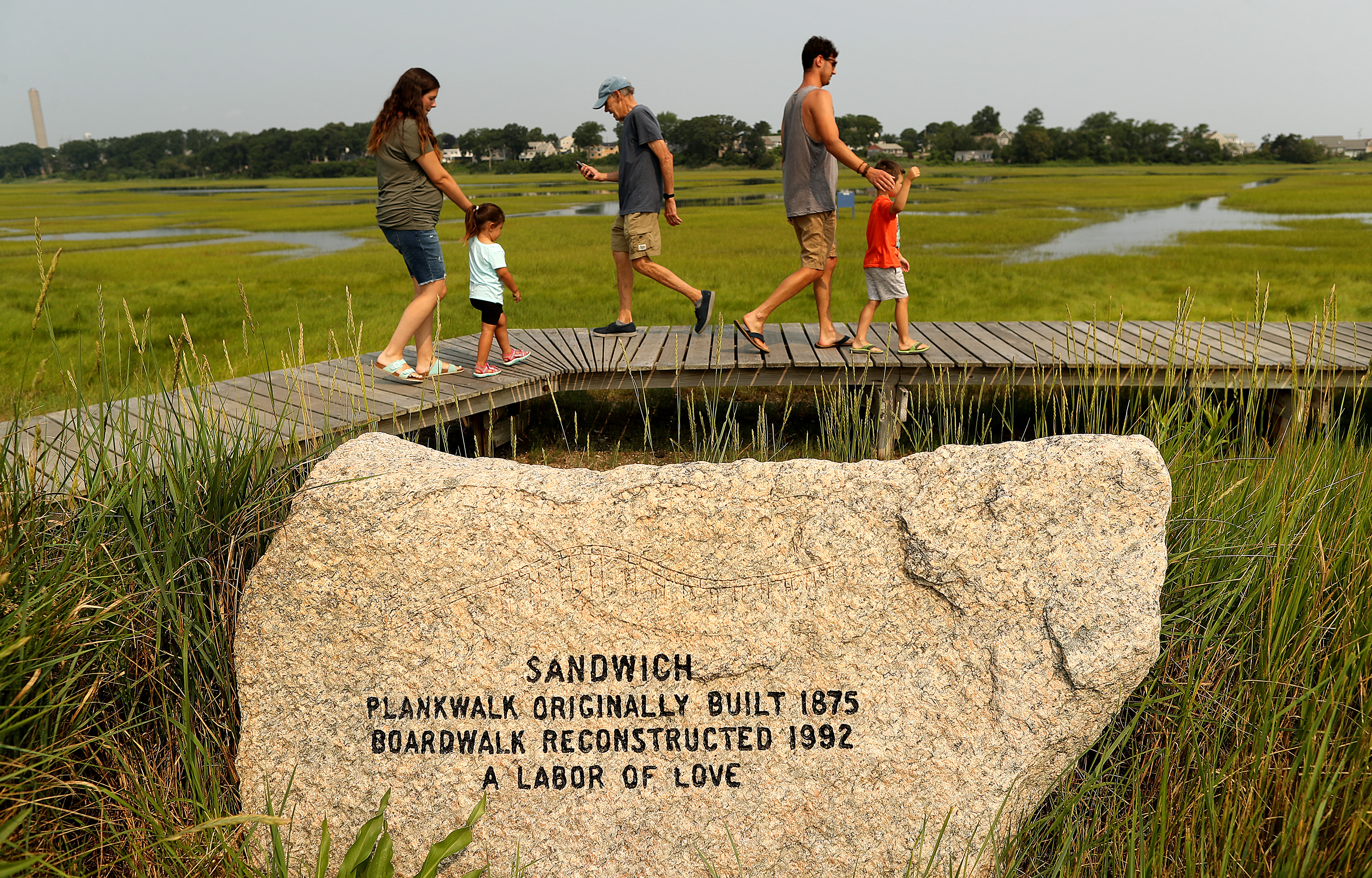 A boulder serves as a marker leading to the Sandwich boardwalk.