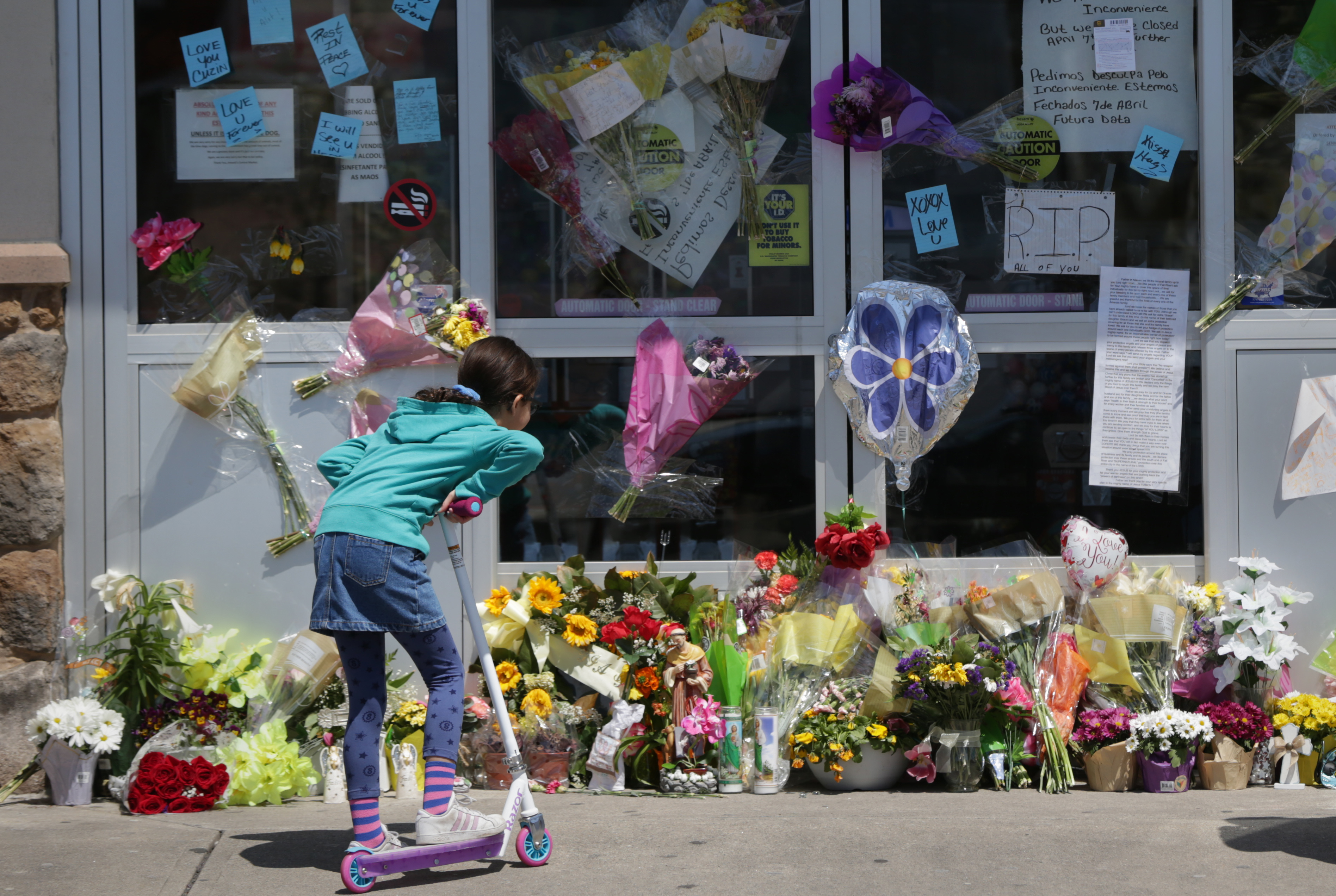 FallRiver MA - 4/25/2020 A young girl take's in a make-shift memorial, in the front of Amaral's Central Market, in Fall River. A beloved family-run business in Fall River, has seen three members of the family have died this month from COVID-19.(Jonathan Wiggs/Globe Staff)