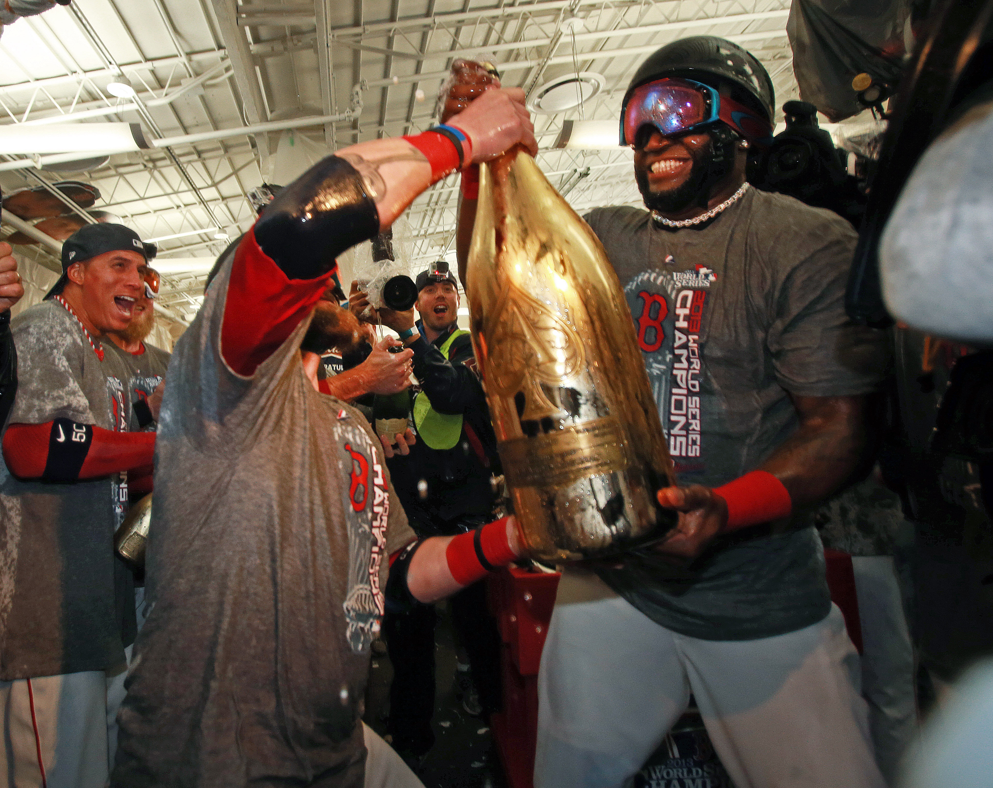 Ortiz and Jonny Gomes (left) hoist a giant bottle of champagne in the clubhouse after winning the World Series.