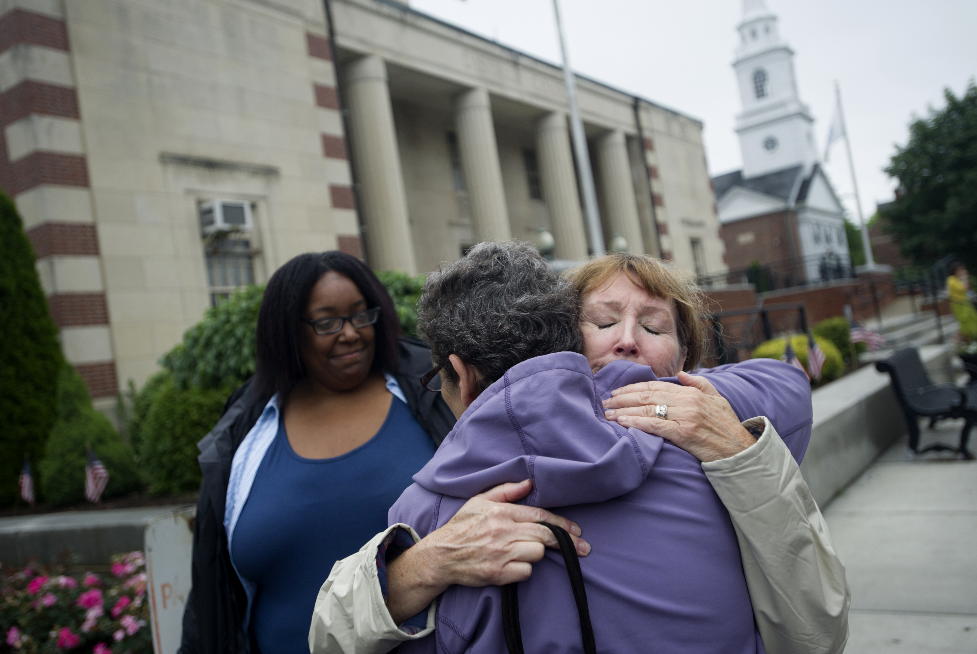 Mike’s girlfriend, Renee Johnson (left), aunt Rhonda Bourne, and mom Peggy Bourne outside Dedham District Court.