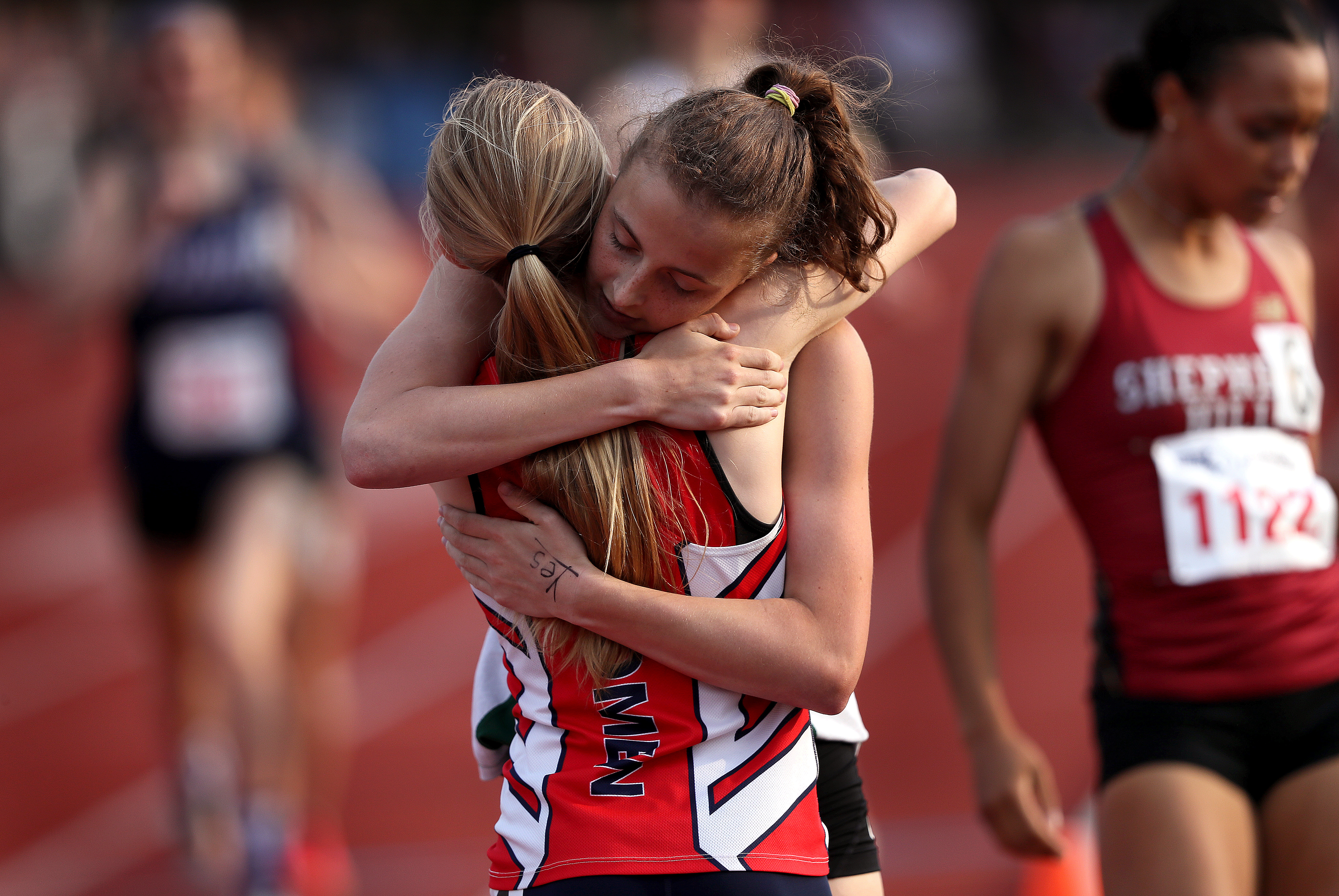 Billerica’s Hannah Doherty embraced Tewksbury’s Makayla Paige after placing second to Paige in the girls’ 800 event at the MIAA All-State meet.