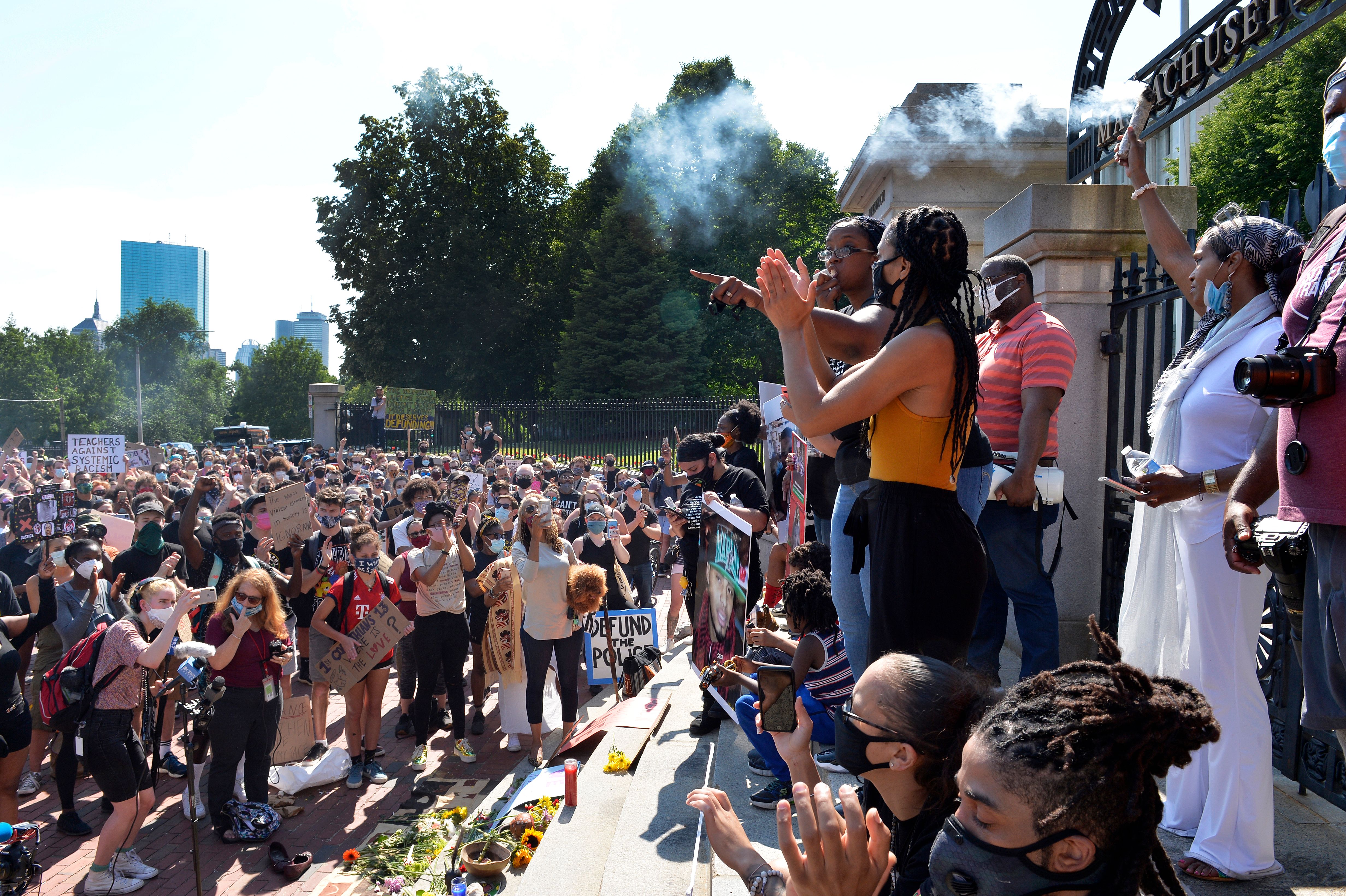 Protesters gather at the State House where Monica Cannon-Grant (center, hand raised) addressed them during a Juneteenth protest and march in honor of Rayshard Brooks and other victims of Police Violence in Boston, Massachusetts on June 22, 2020. (Photo by Joseph Prezioso / AFP) (Photo by JOSEPH PREZIOSO/AFP via Getty Images)