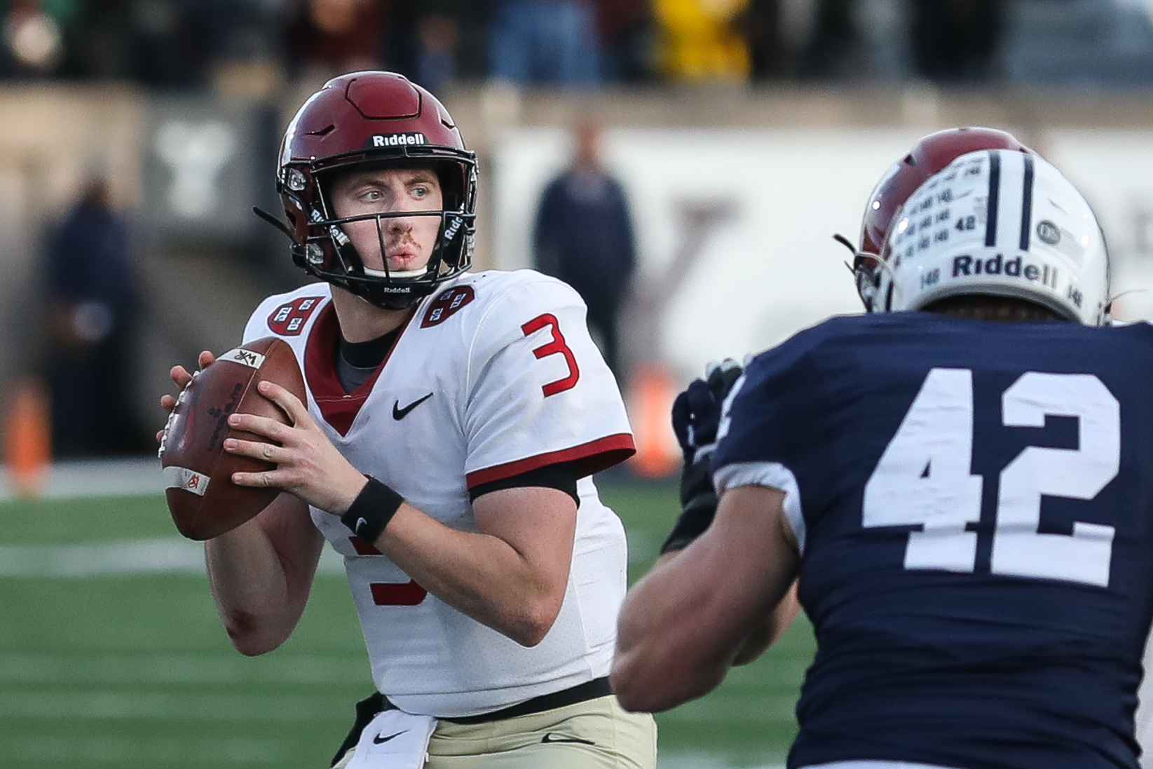 Harvard quarterback Luke Emge looks for a pass during the fourth-quarter.
:
