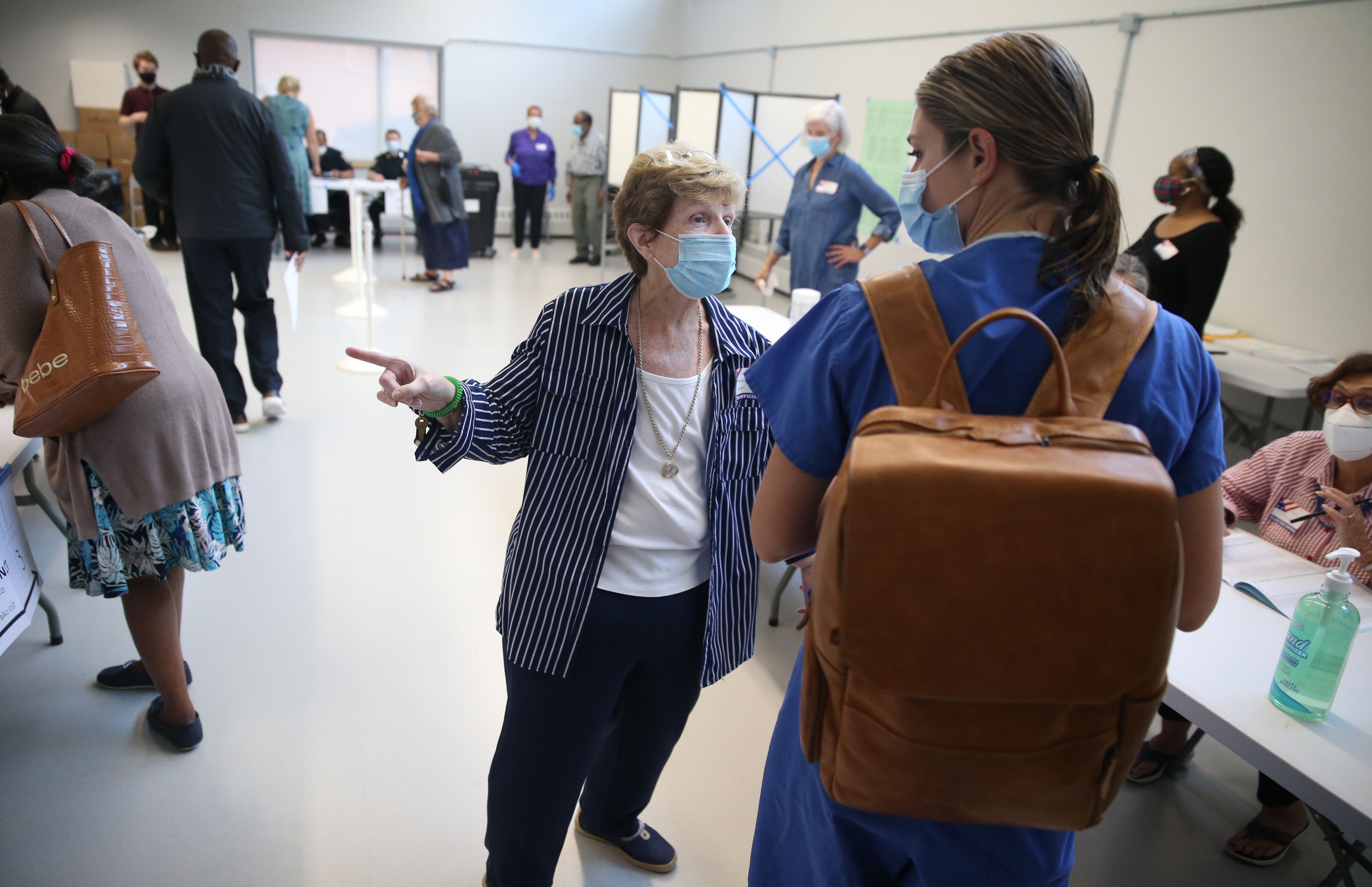 Theresa Dolan (left) helps a voter at polling place in Lower Mills Library, on 27 Richmond St, Dorchester.