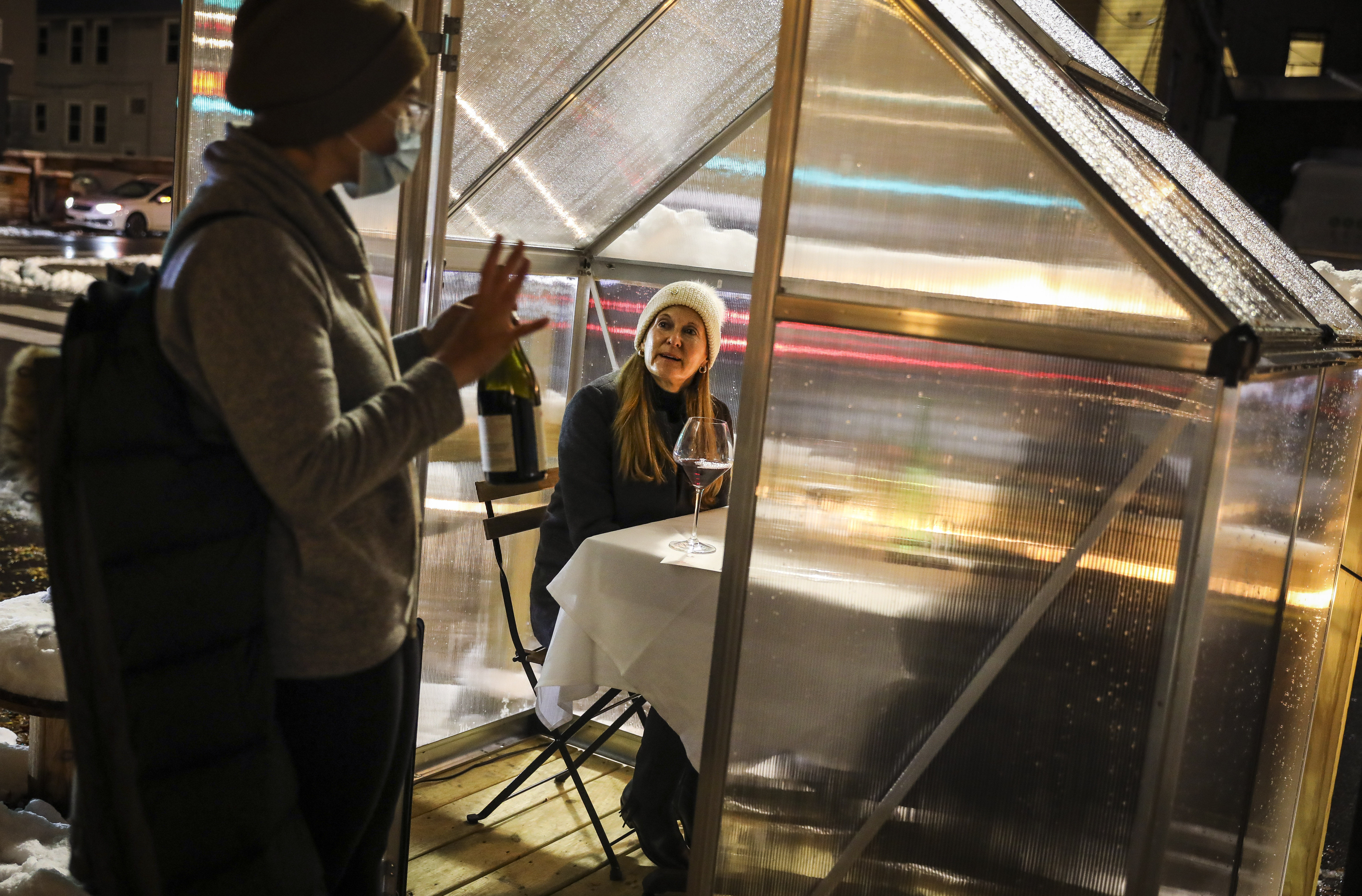 Danielle Ayer, owner of Talulla, brings out wine to restaurant-goers Audrey and Steven Reny.