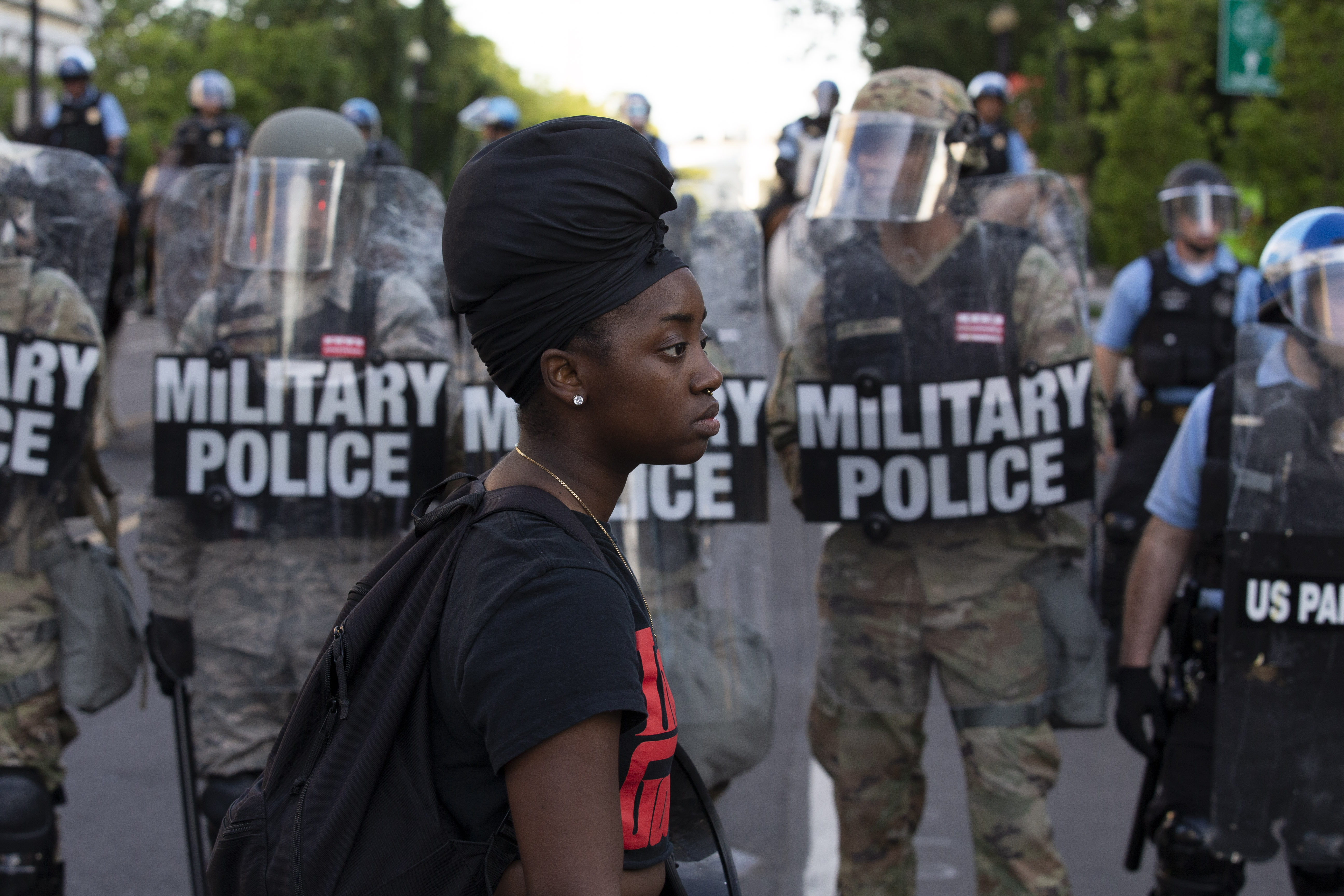 A demonstrator walks in front of a row of military police wearing riot gear as they push back demonstrators outside of the White House in June during a protest over the police killing of George Floyd.