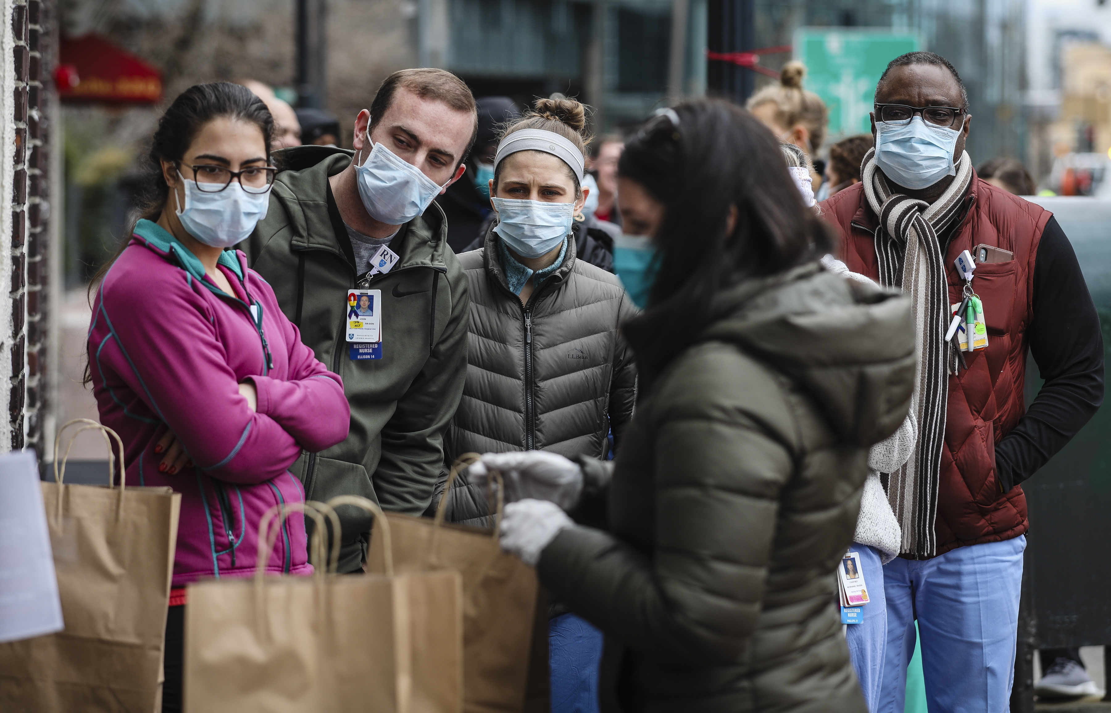 BOSTON - 4/1/2020:  MGH employees wait outside of Harvard Gardens to get a free bagged lunch on Wednesday afternoon. Massachusetts General Hospital has been hit hard with coronavirus cases over the past few weeks and employees have been working around the clock to bring relief to the COVID-19 pandemic that has rocked the world. (Erin Clark/Globe Staff)