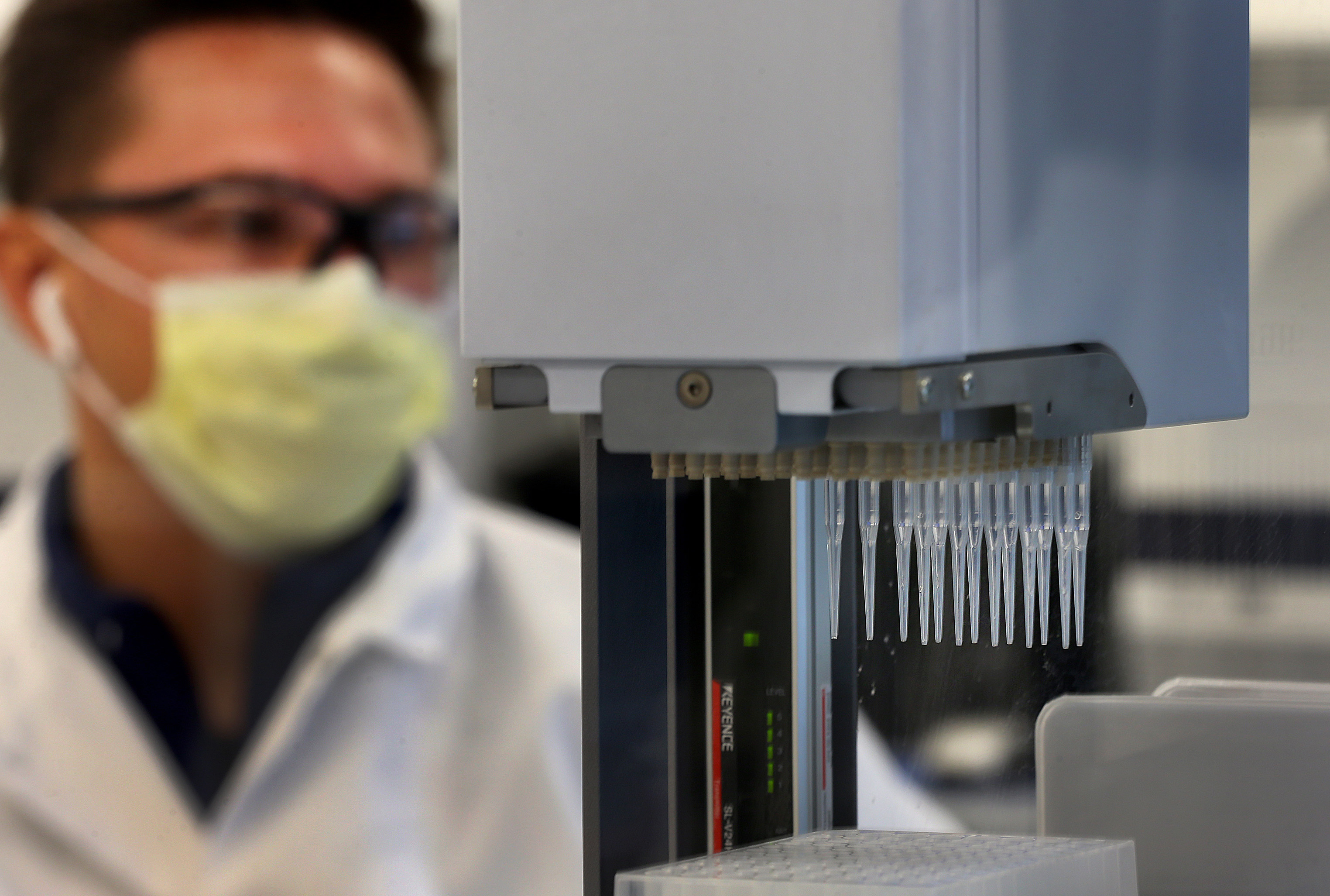 Clinical lab technician Zachary Anderson monitored a robotic procedure which separates wastes from the sample vials before they are tested for the virus.