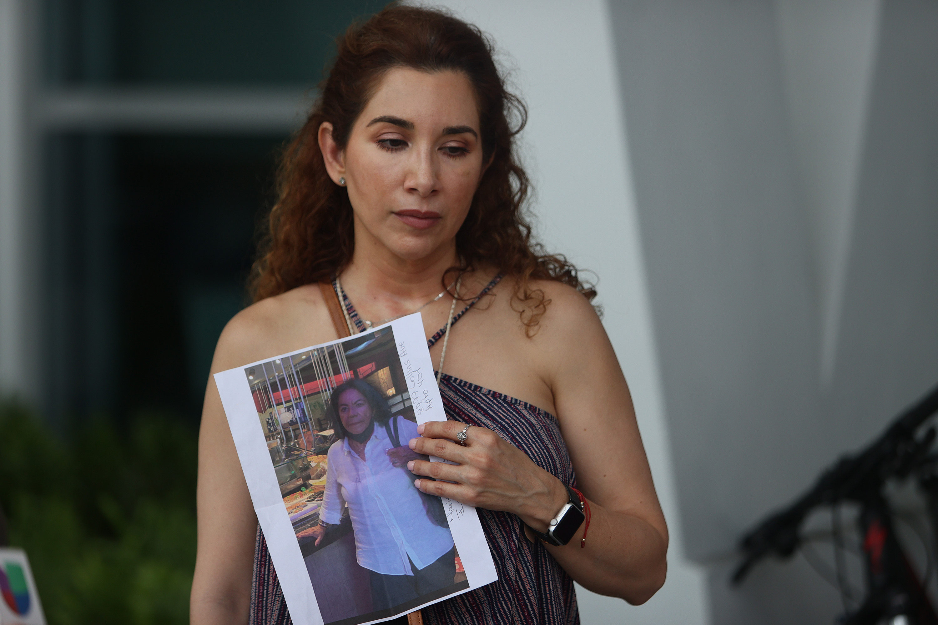 Luz Marina held a picture of her aunt, Marina Azen, who she said is missing.