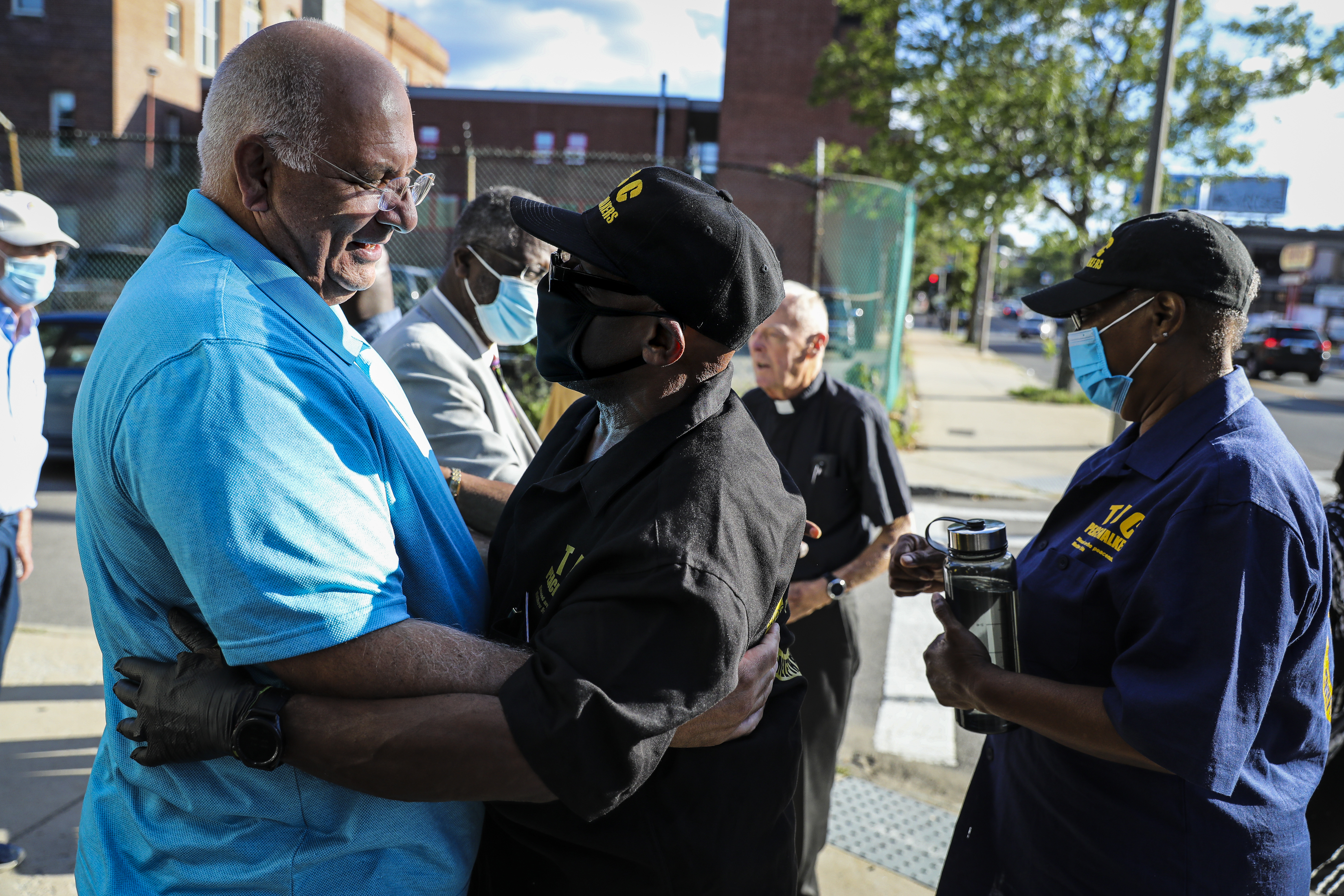 Former Boston police commissioner Dennis White (left) hugged the Rev. Arthur Gerald Jr.