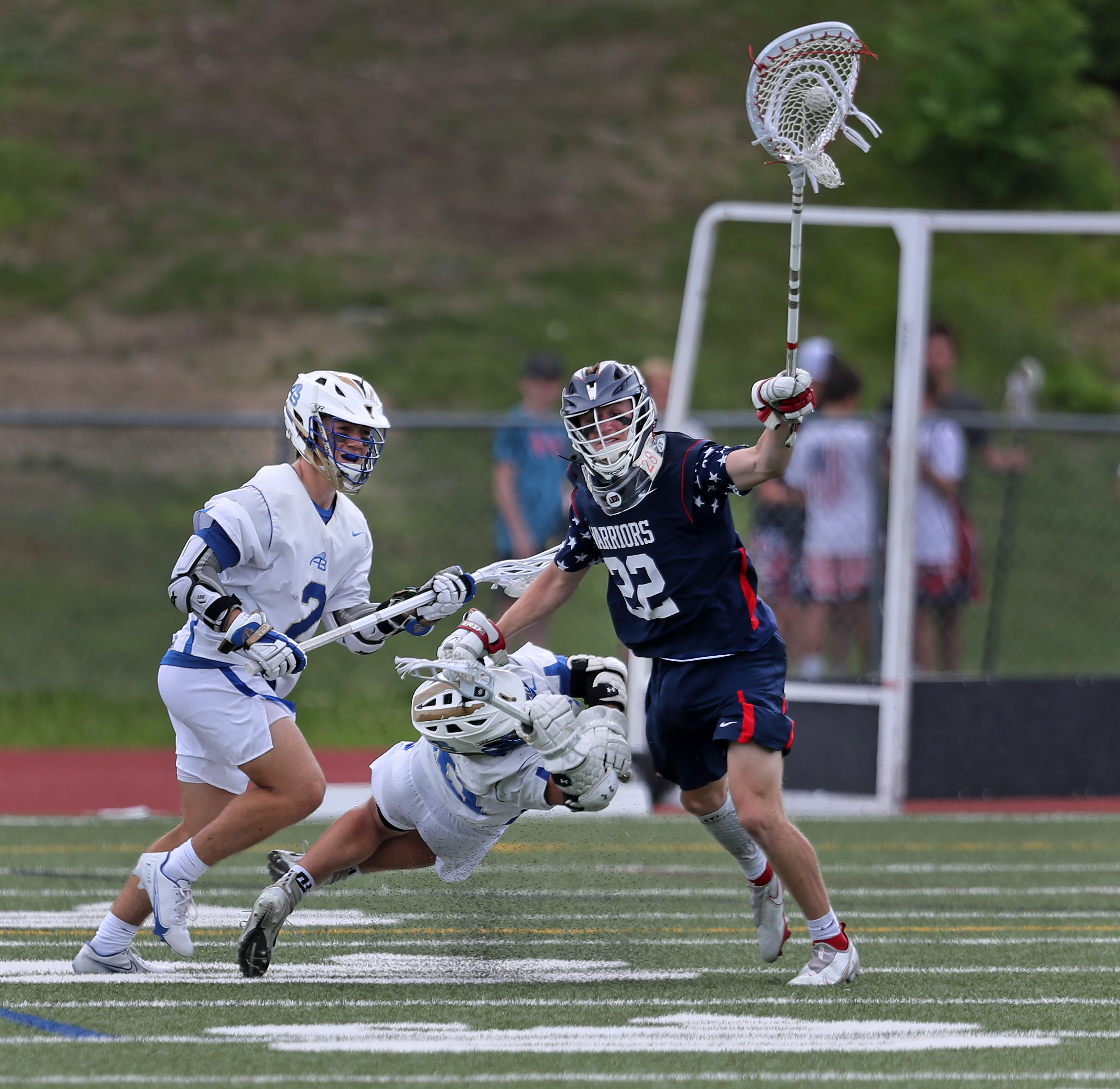 Lincoln-Sudbury goalie Nolan O'Brien (22) kept his stick high as he single-handedly kept at bay Acton-Boxboro's defenders Brady Graham (left) and a diving Sal Panetta (center) during the second quarter.