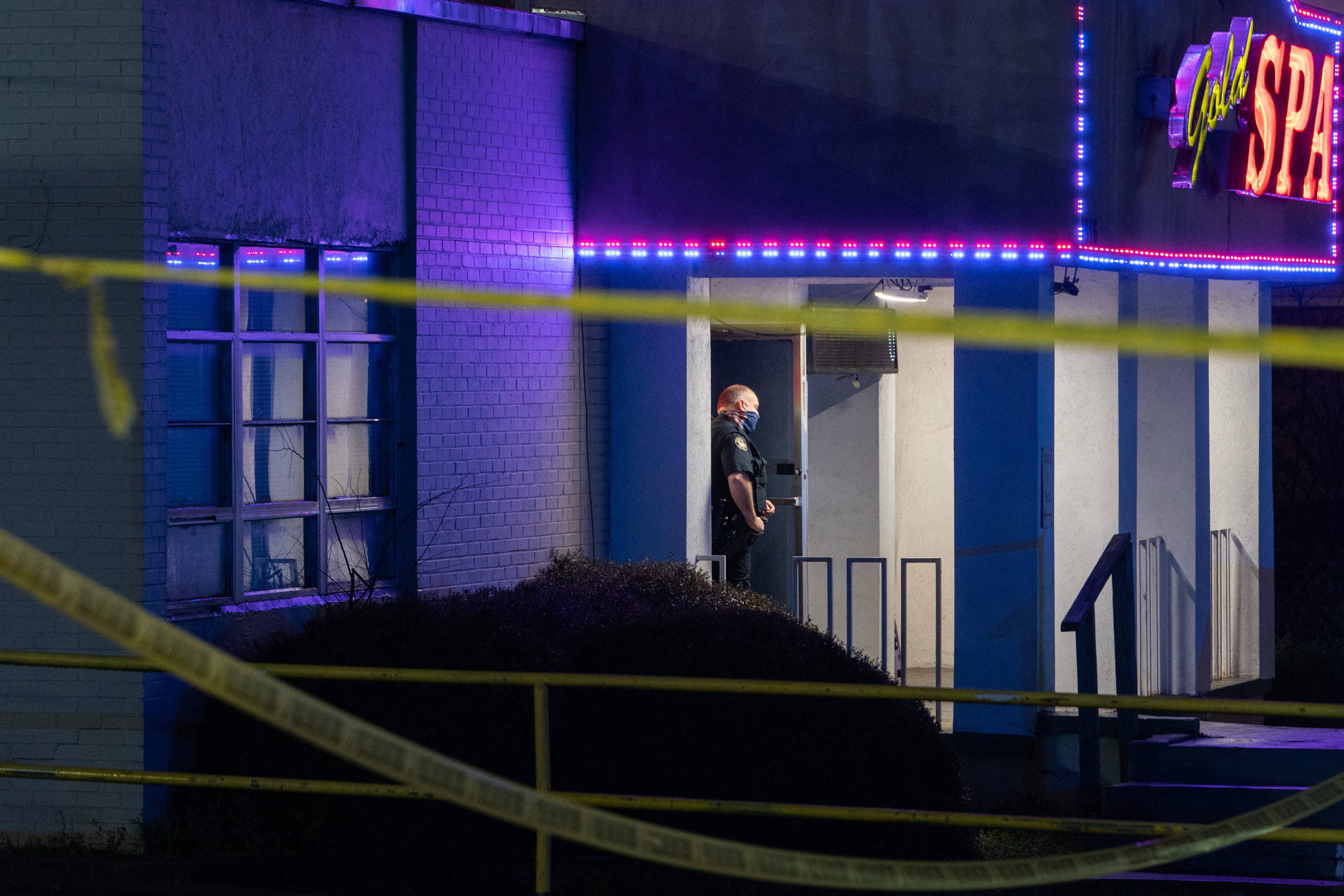 A police officer stood outside a massage parlor where three people were shot and killed in Atlanta on Tuesday.