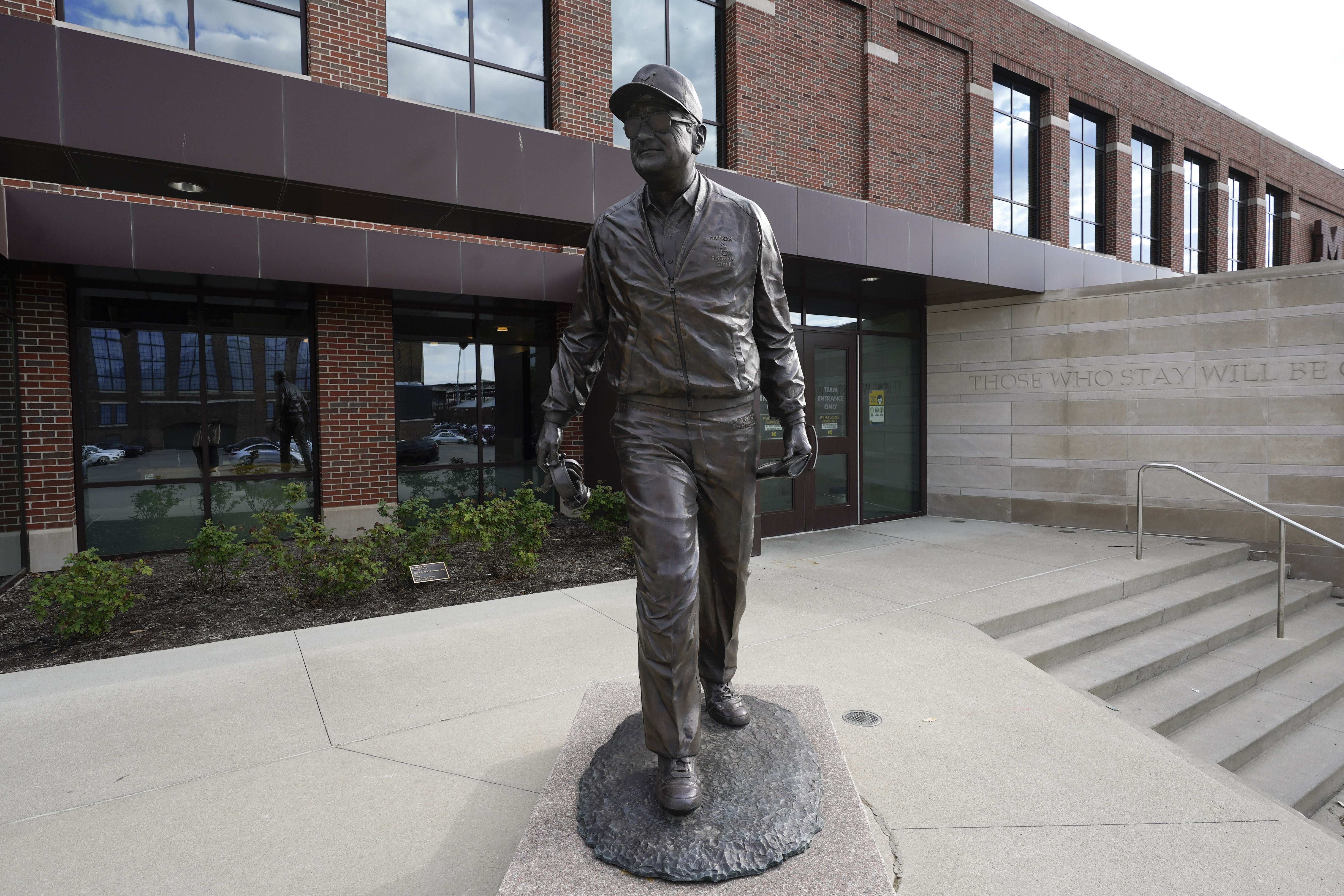 A statue of Bo Schembechler stands in front of Schembechler Hall on the campus of the University of Michigan.