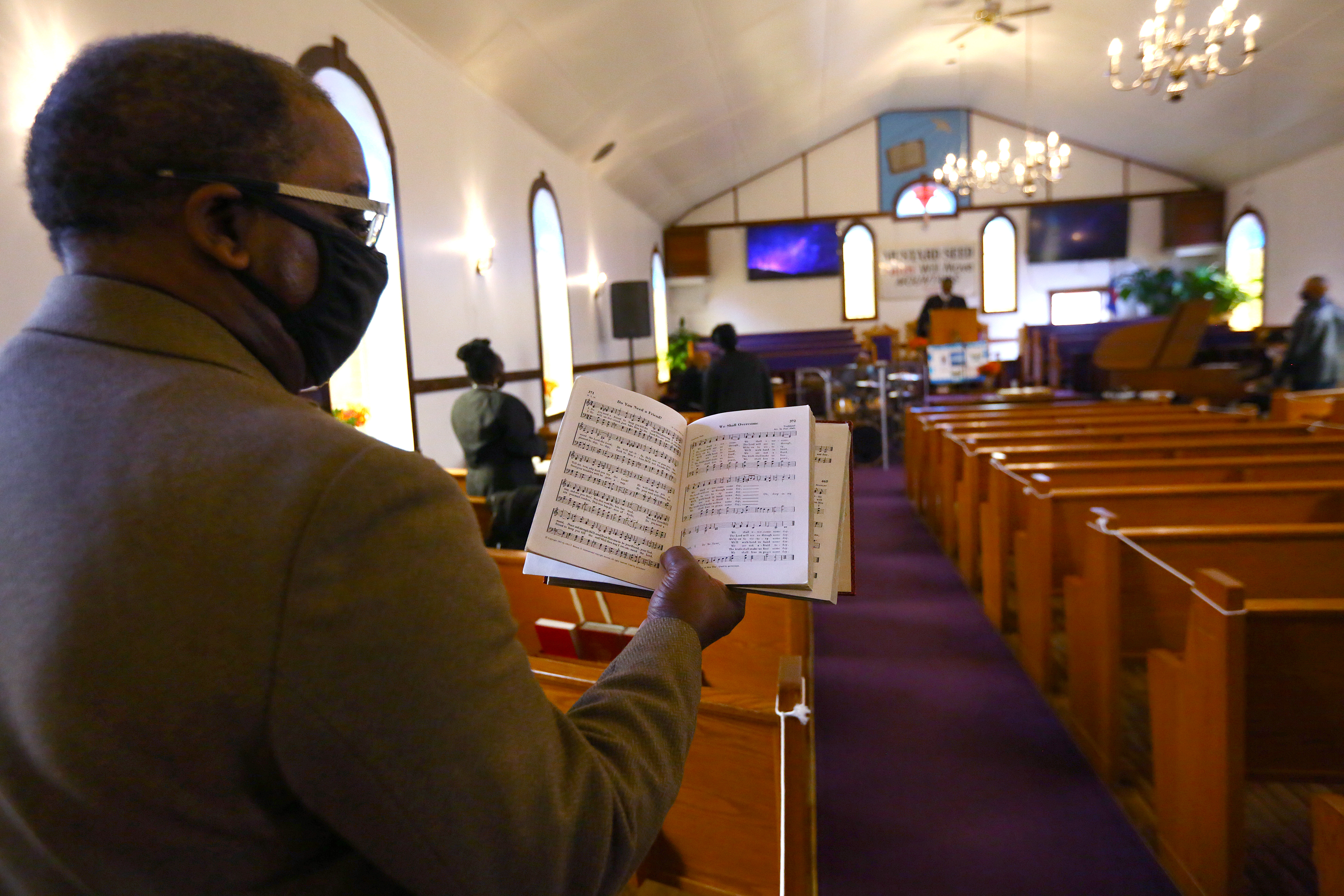 Near the end of Sunday's service, "We Shall Overcome" was sung in honor of Dr. Martin Luther King Jr. at Pleasant Hill Missionary Baptist Church. Deacon Joseph Britt held the hymnal.