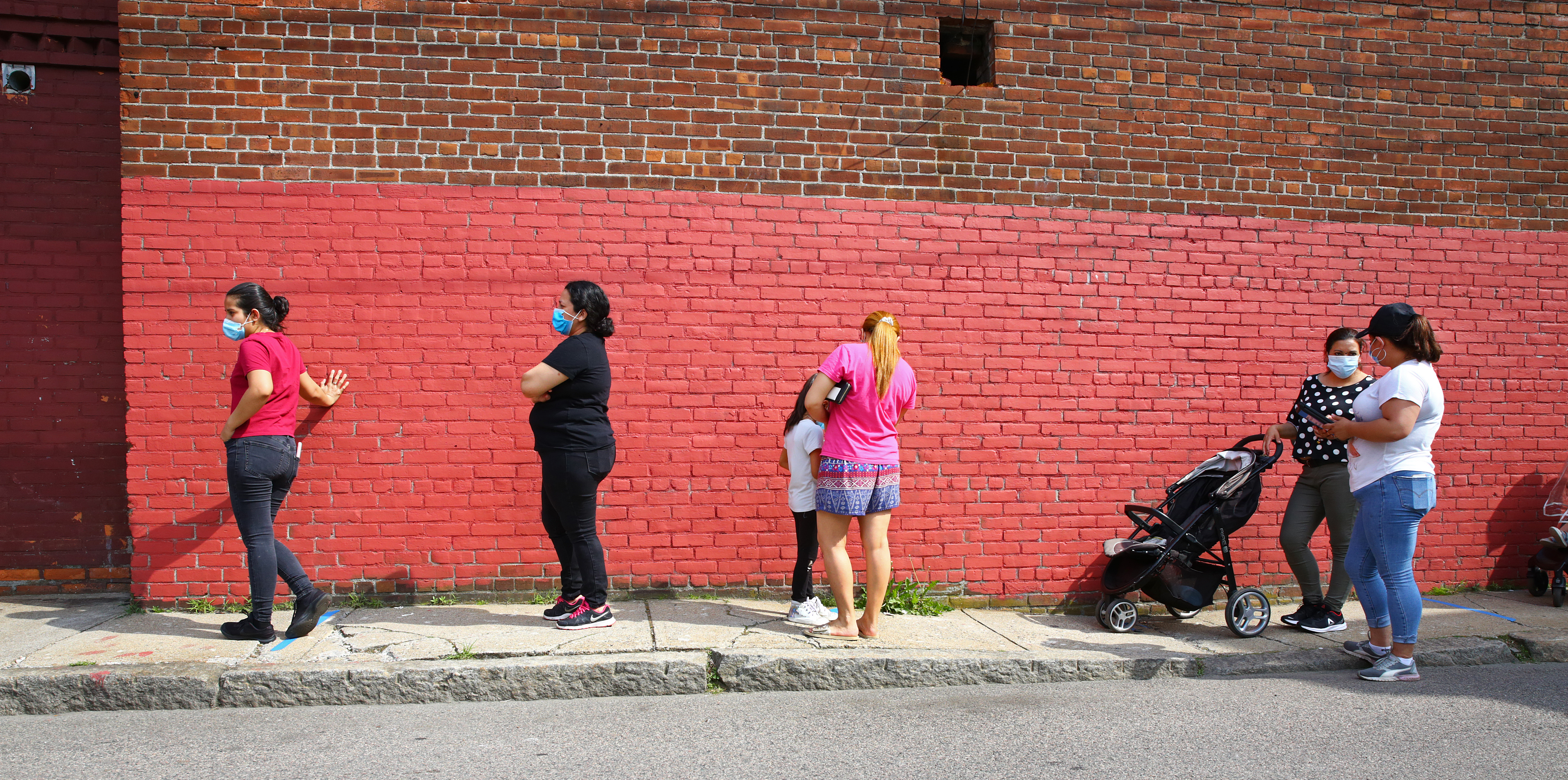 2020 Census field organizer Estephany Escobar (right) interviews a resident in the food pantry line at the Chelsea Collaborative last week.