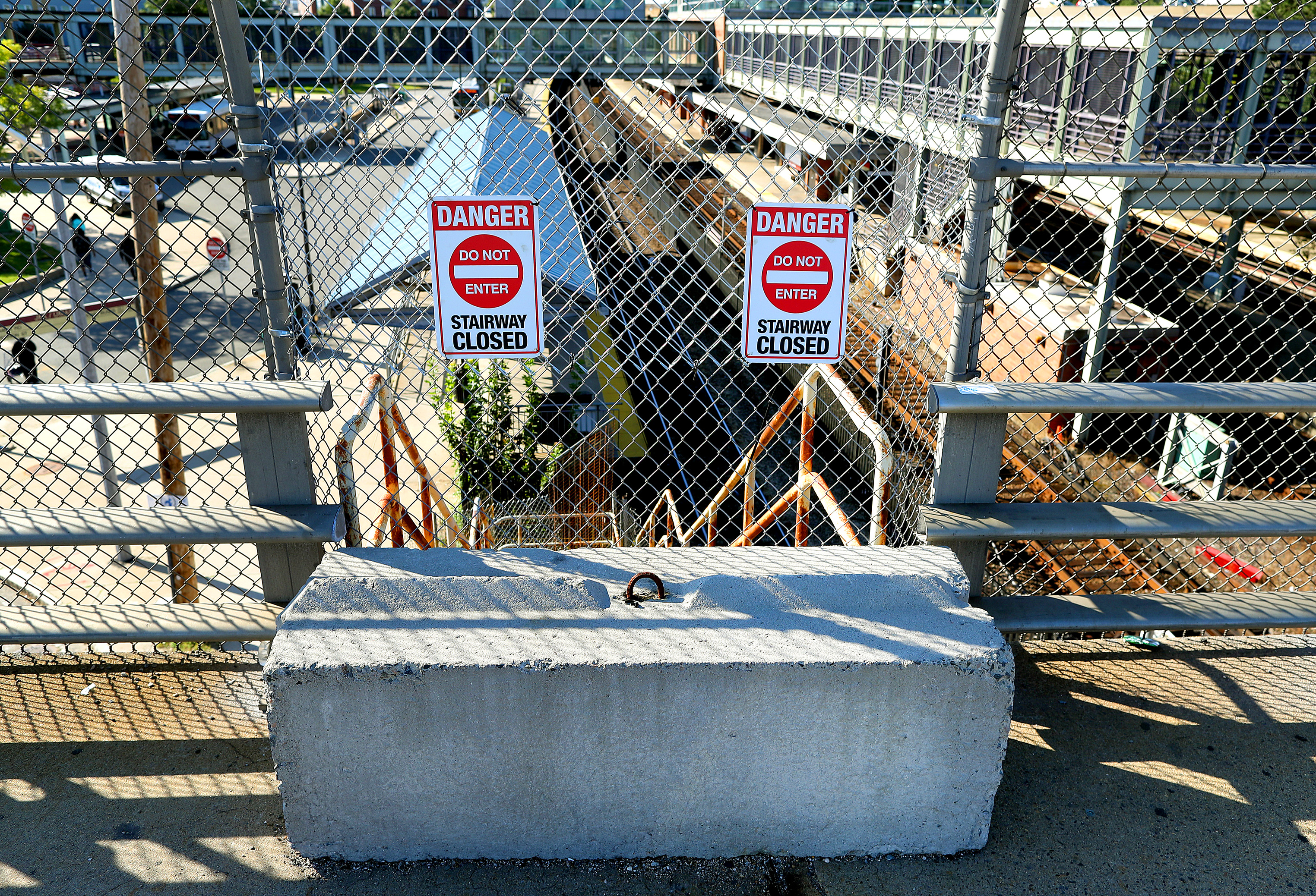 A jersey barrier and chain link fence blocked access at the top of the stairway.