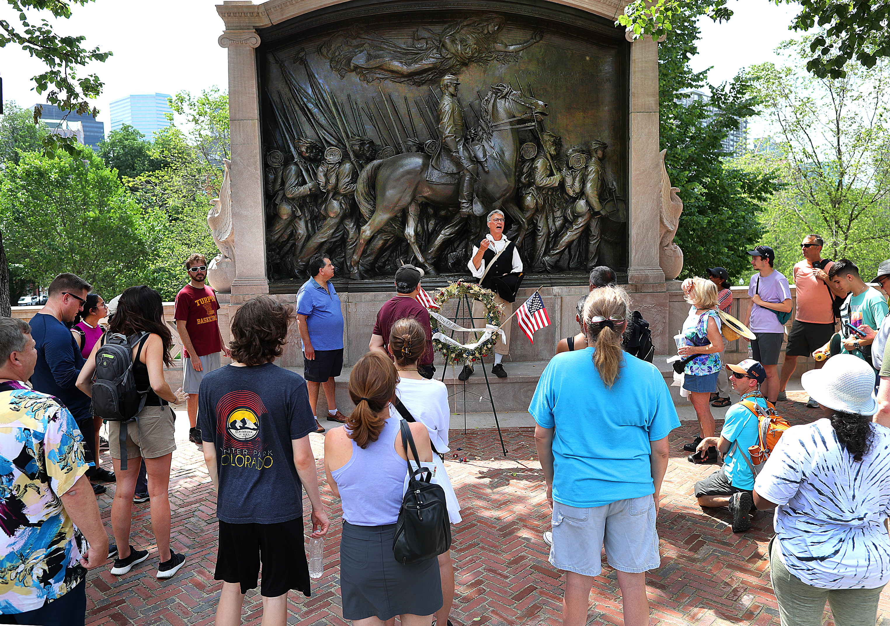 A crowd gathered around the memorial to Robert Gould Shaw and the 54th Massachusetts Regiment in front of the State House.