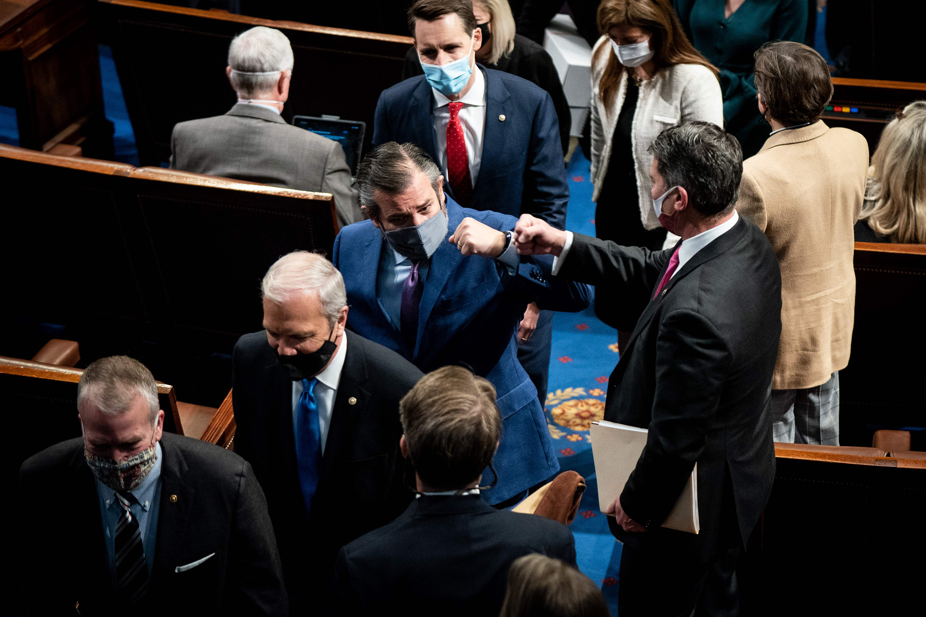 Texas Senator Ted Cruz (center) fist-bumped a House member Wednesday during a break in a joint session of Congress to certify the electoral votes.