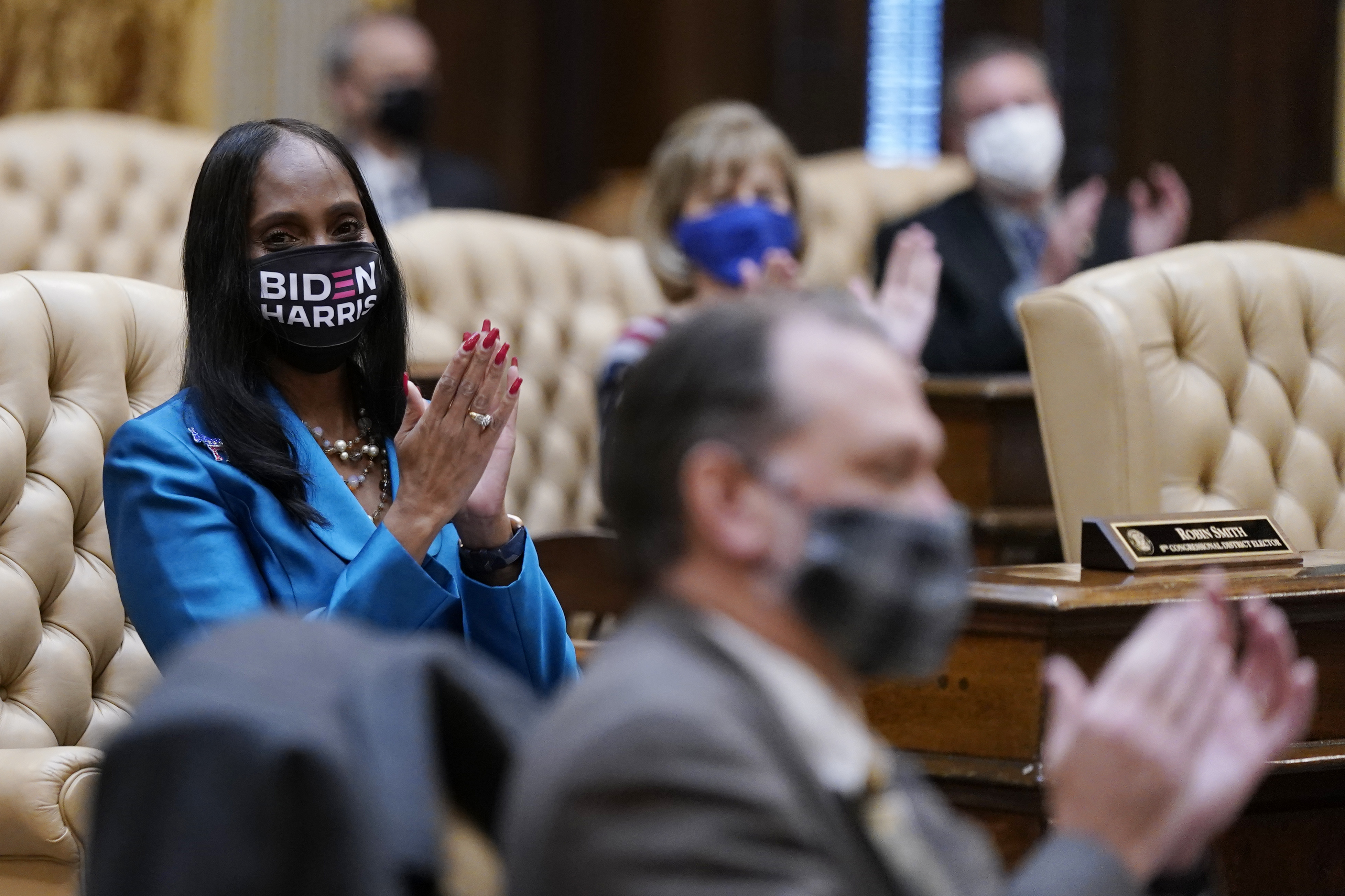 Electoral College elector Robin Smith (L) and others clapped after casting their votes for President of the United States at the state Capitol on Monday in Lansing, Michigan.