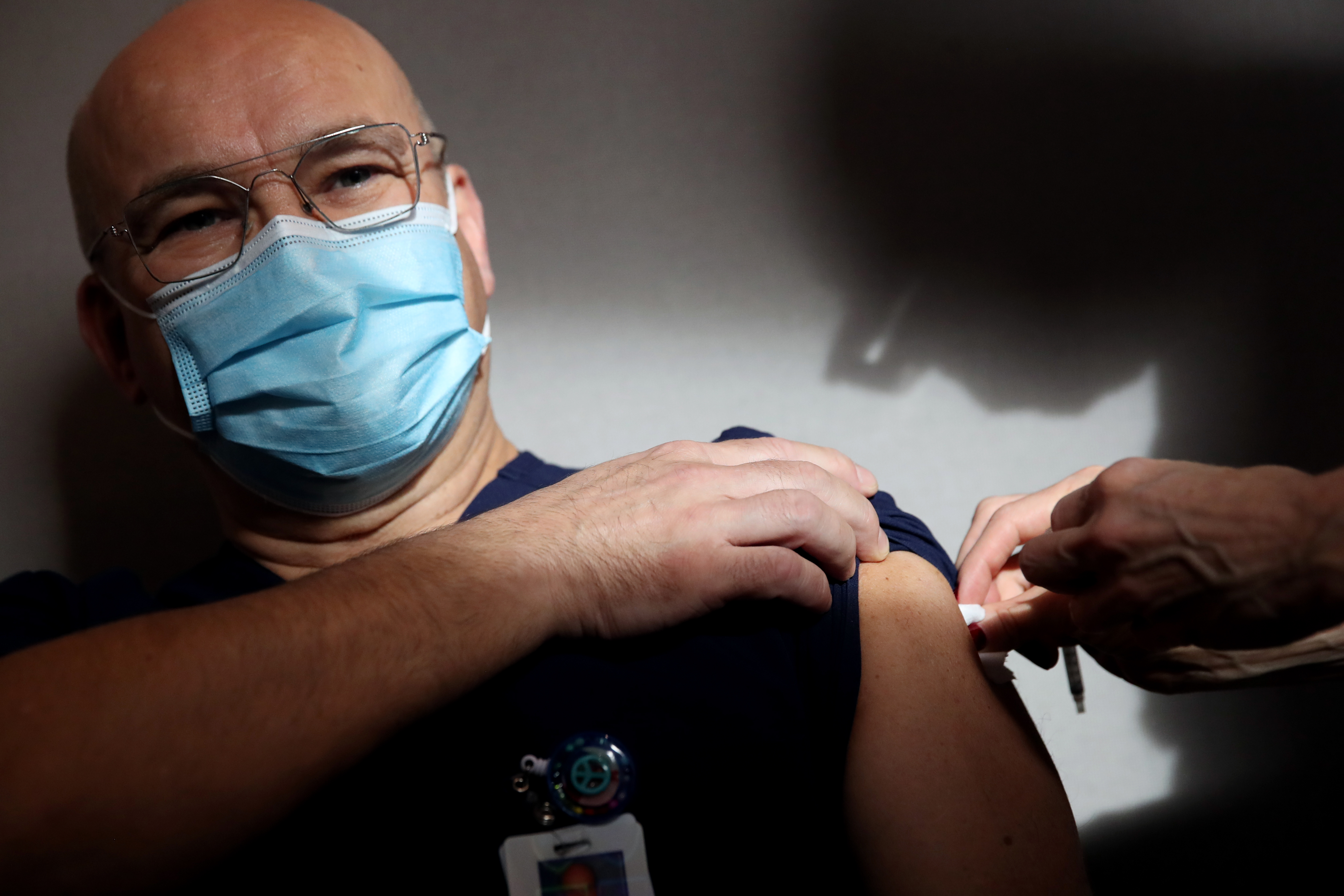 Medical intensive care unit nurse Tor Hansen received one of the first doses of the Pfizer-BioNTech coronavirus vaccine from RN Jennifer Lisciotti at Massachusetts General Hospital in Boston on Dec. 16, 2020.