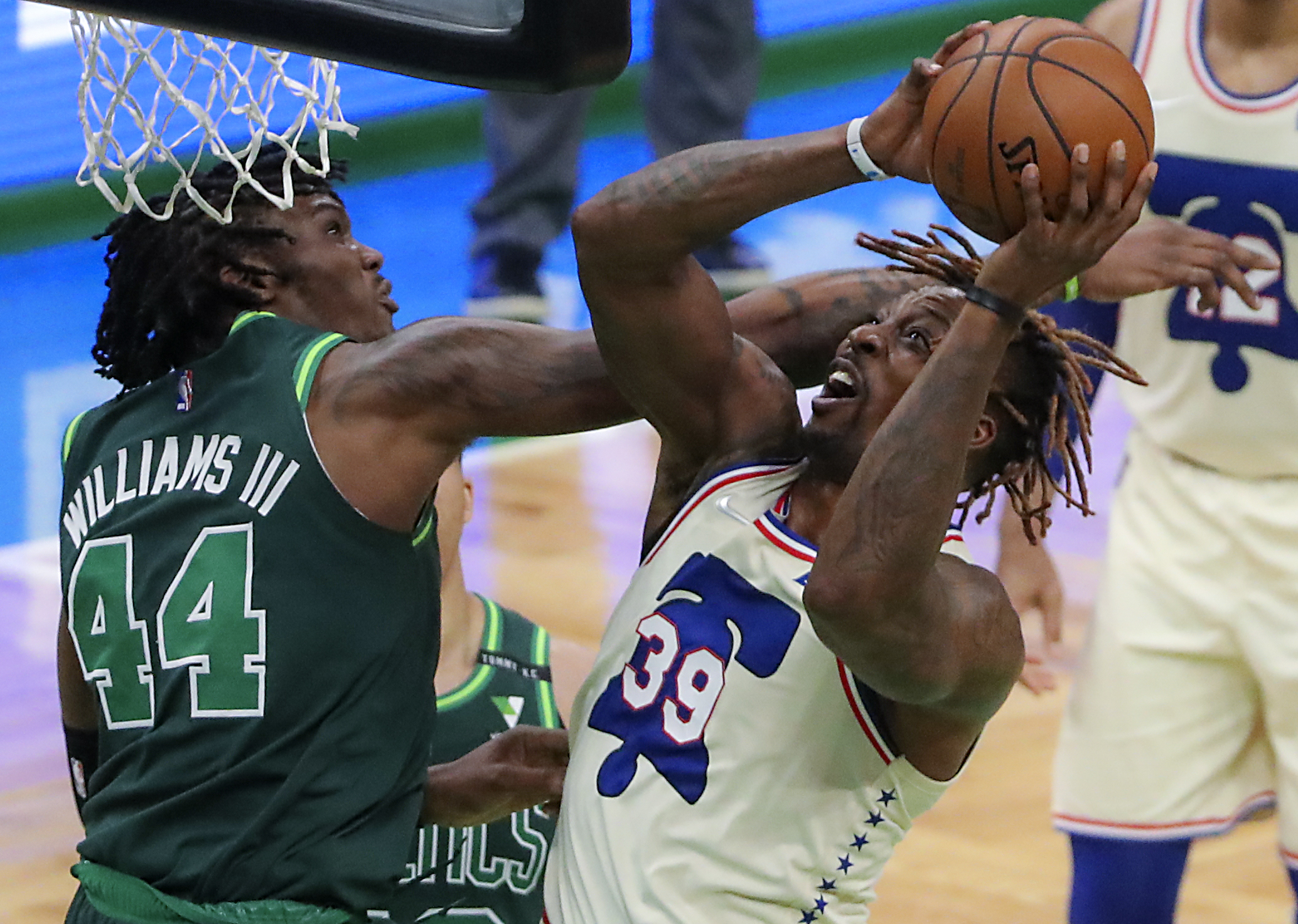 Robert Williams III fouls out of the game as he connects with Philadelphia's Dwight Howard during fourth-quarter action Tuesday night at the TD Garden.