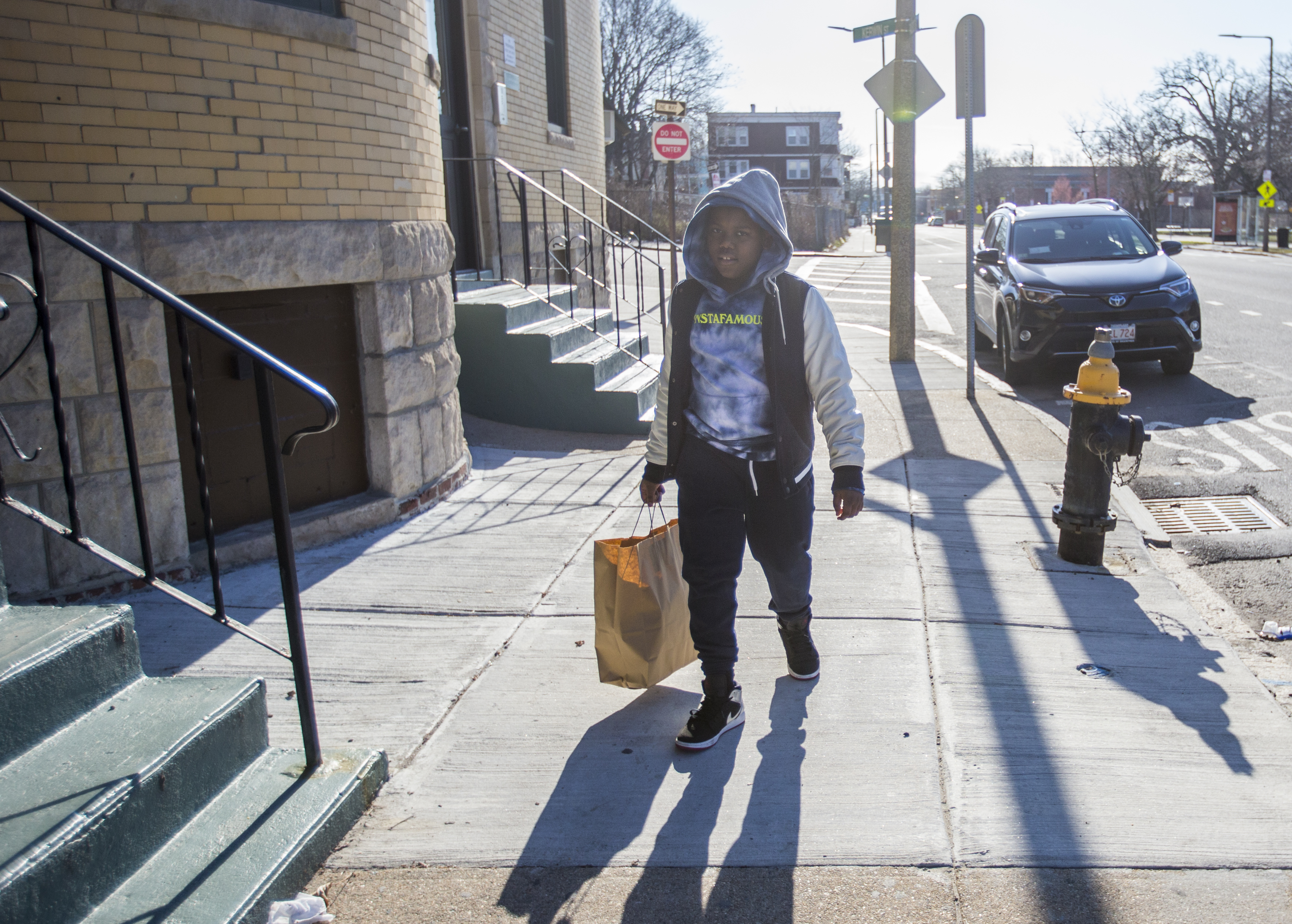 Malaki Solo walked to take a bag of groceries back to his home from Joseph Lee K-8 school.