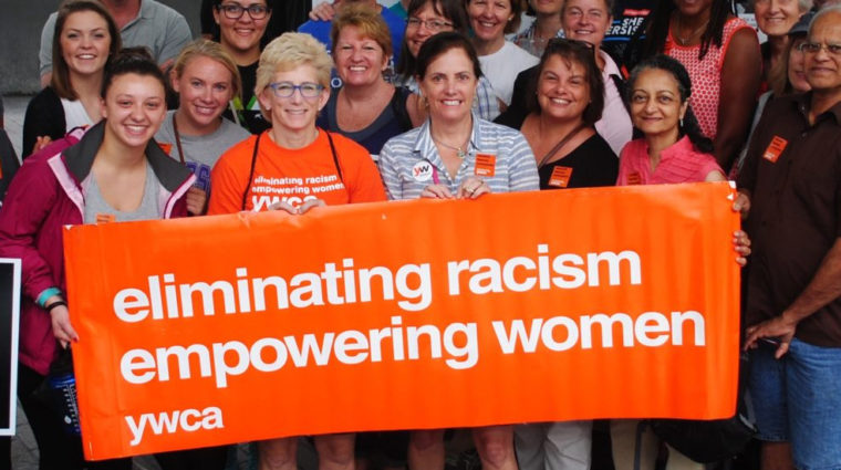Cartel del YWCA que dice "Eliminando el racismo, empoderando a las mujeres"