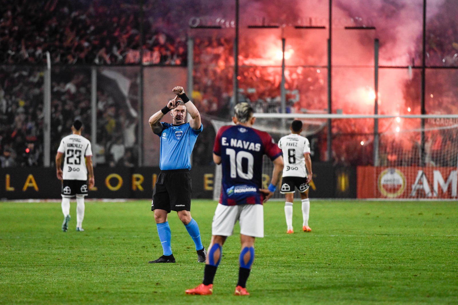 El juez Anderson Daronco detiene el cronómetro con fuegos artificiales de fondo