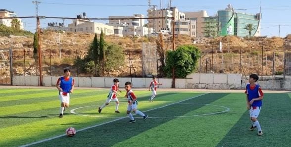 Un entrenamiento de la escuela de fútbol de Palestina, con Ramallah de fondo.