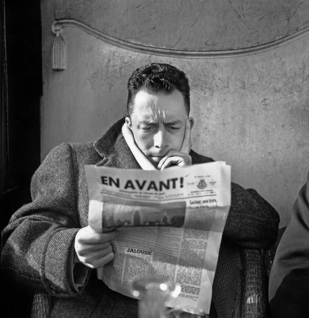 Albert Camus leyendo el periódico.