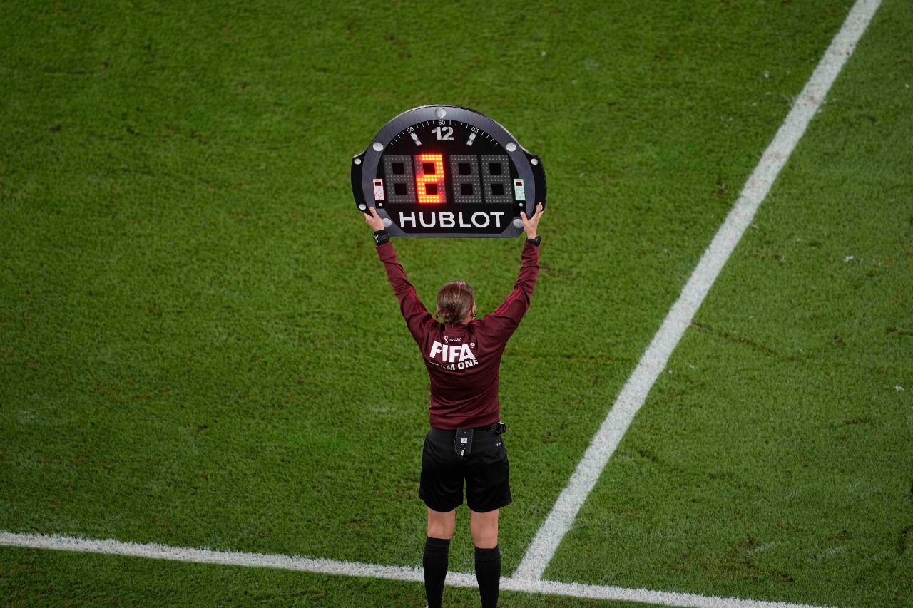 Un juez asistente indica el tiempo adicional en un partido del Mundial