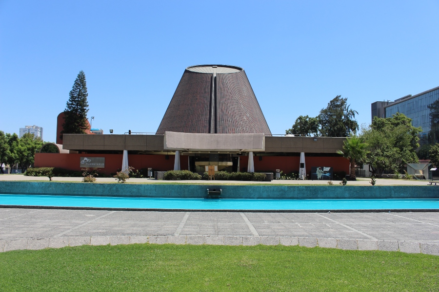 Edificio cónico del Planetario USACH frente a su espejo de agua
