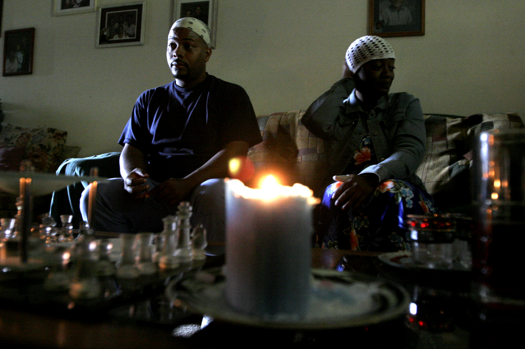 Stephen Owens (left) and Krisiti Wallace (right) use candles and leave the front door open to let light into their basement apartment at Westbrooke Village Apartments in Trotwood Sunday Sept. 21. About 20 residents held a protest earlier in the day because they have been without power for a week since a windstorm came through the area Sept. 14. Staff photo by Lisa Powell
