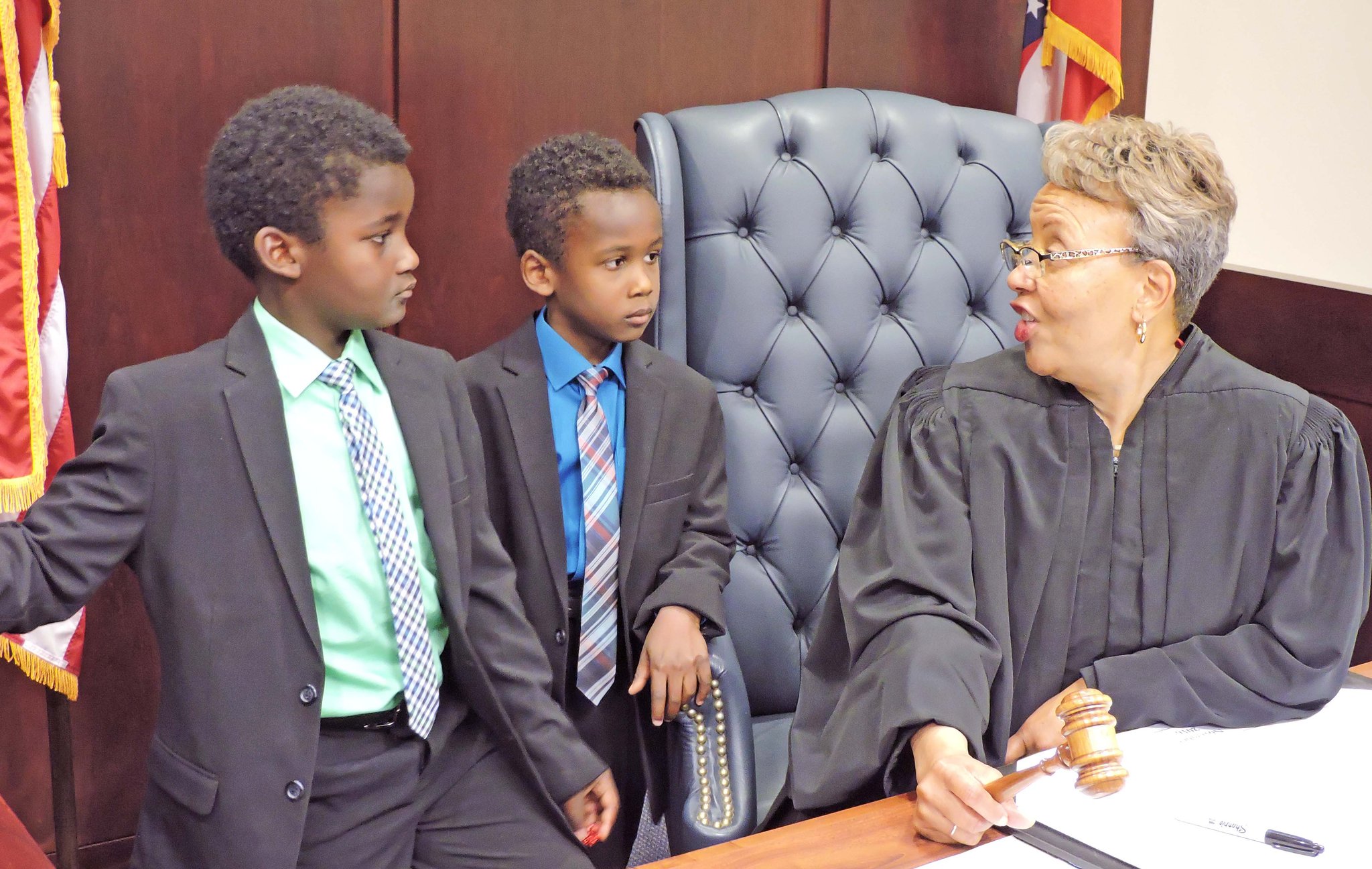 Montgomery County Probate Court Judge Alice O. McCollum interacts with two boys who just joined their forever family, the Lamberts. Josiah, 8, on the left, and Gabriel, 6, were two of 15 adoptions finalized in Judge McCollum’s court in celebration of National Adoption Day in November. CONTRIBUTED