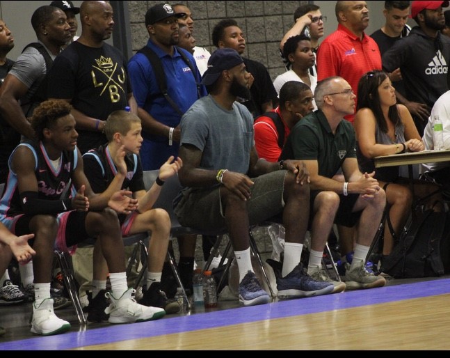 From left, Bronny James, Gabe Cupps, LeBron James and Brook Cupps on the bench during an AAU game. CONTRIBUTED