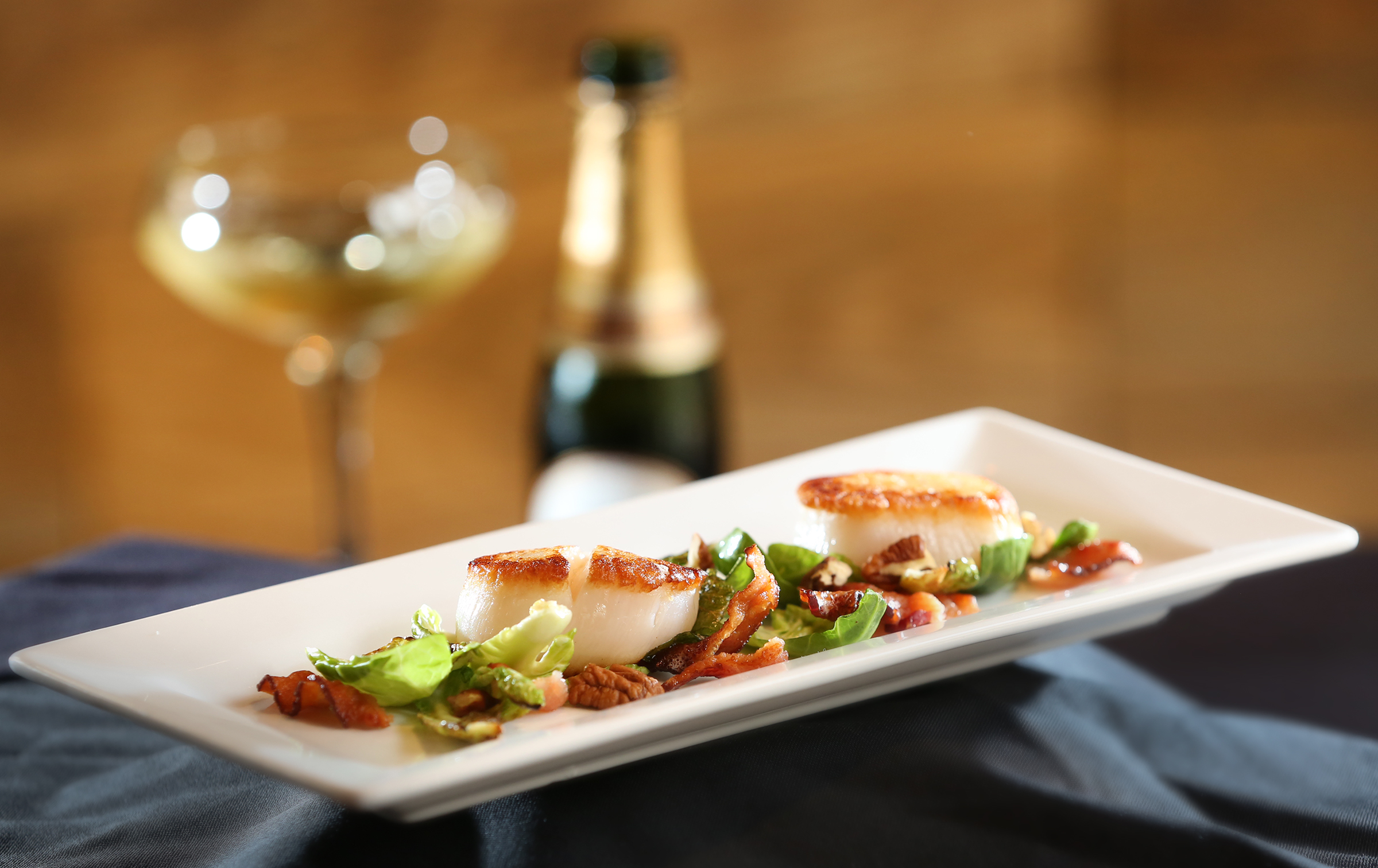 Salt-crusted scallops with brussel chips, applewood smoked bacon and pecans served with Laurent-Perrier champagne at Roost Modern Italian in the Oregon District. The restaurant was founded by chef Dana Downs who takes traditional Italian foods and uses modern techniques and ingredients to develop unique flavors. The dinner-only restaurant is located at 524 E. Fifth St. in Dayton. LISA POWELL / STAFF