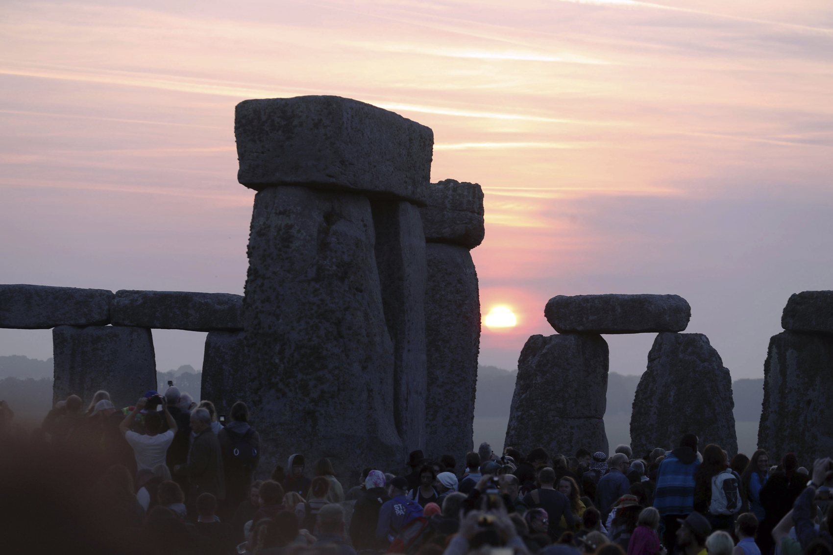 Some thousands of people watch the sun rise while standing among the ancient stones at Stonehenge, to celebrate the Summer Solstice at Stonehenge in Salisbury, England, early Wednesday June 21, 2017. The prehistoric monument, Stonehenge is about 5000-years old and is thought to have been constructed to mark the movement of the sun and other heavenly objects according to Pagan rites. (Steve Parsons/PA via AP)