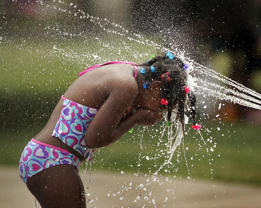 Cianna Richarson gets immersed in the cooling water jets of the spray at McIntosh Spray Park on Riverview Ave.