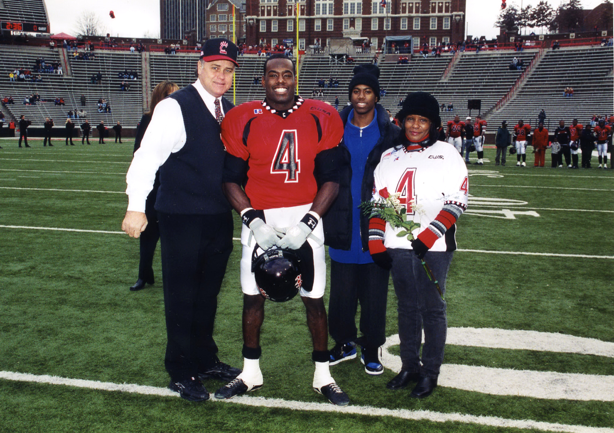 LaVar Glover (center in uniform) is pictured in this 2001 photo with University of Cincinnati Football Coach (left) Rick Minter, his brother James Phillips and his mother (right). Photo submitted by LaVar Glover.
