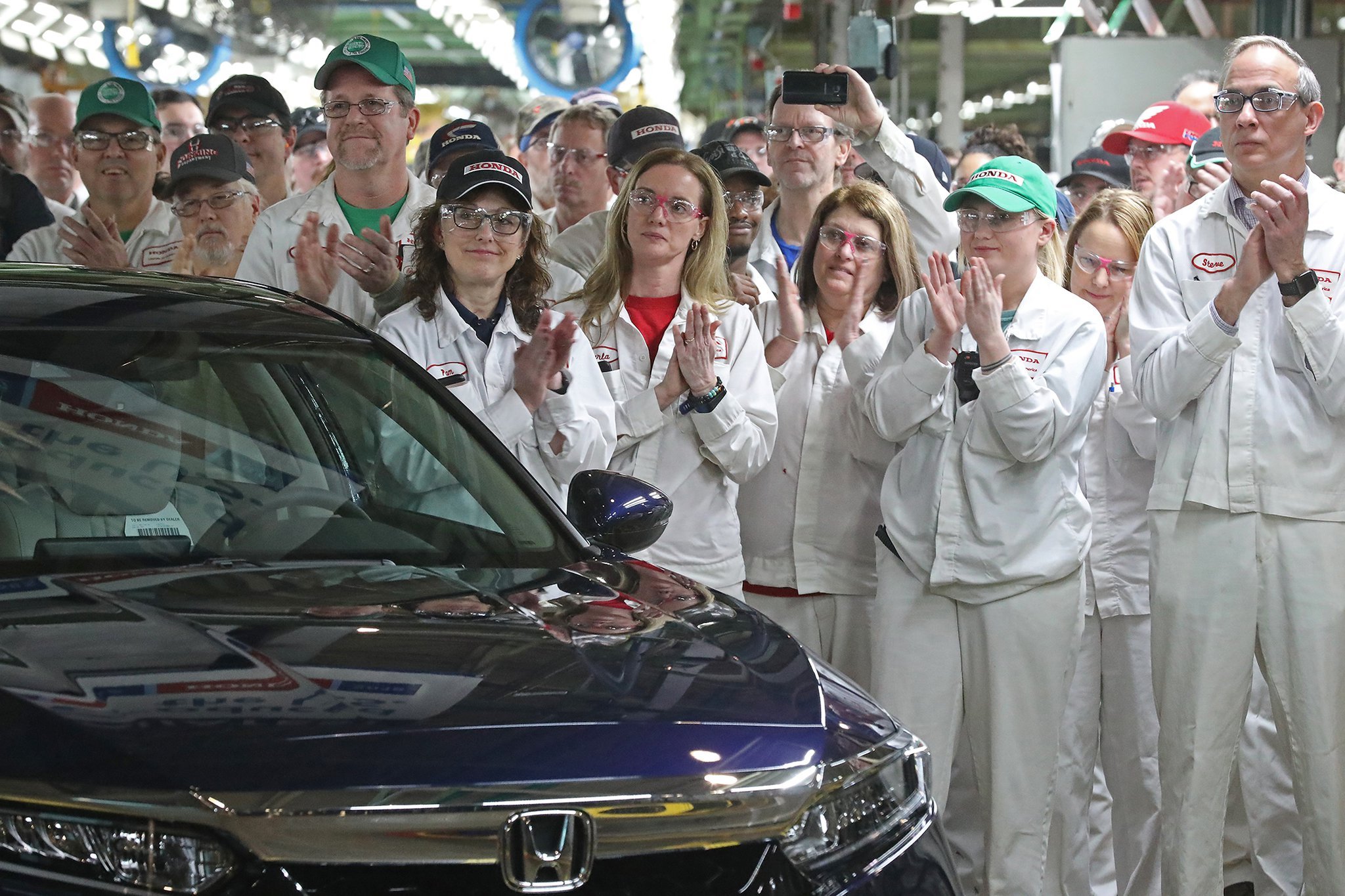Workers work on a manufacturing line at Honda plant in Anna, Ohio. BILL LACKEY