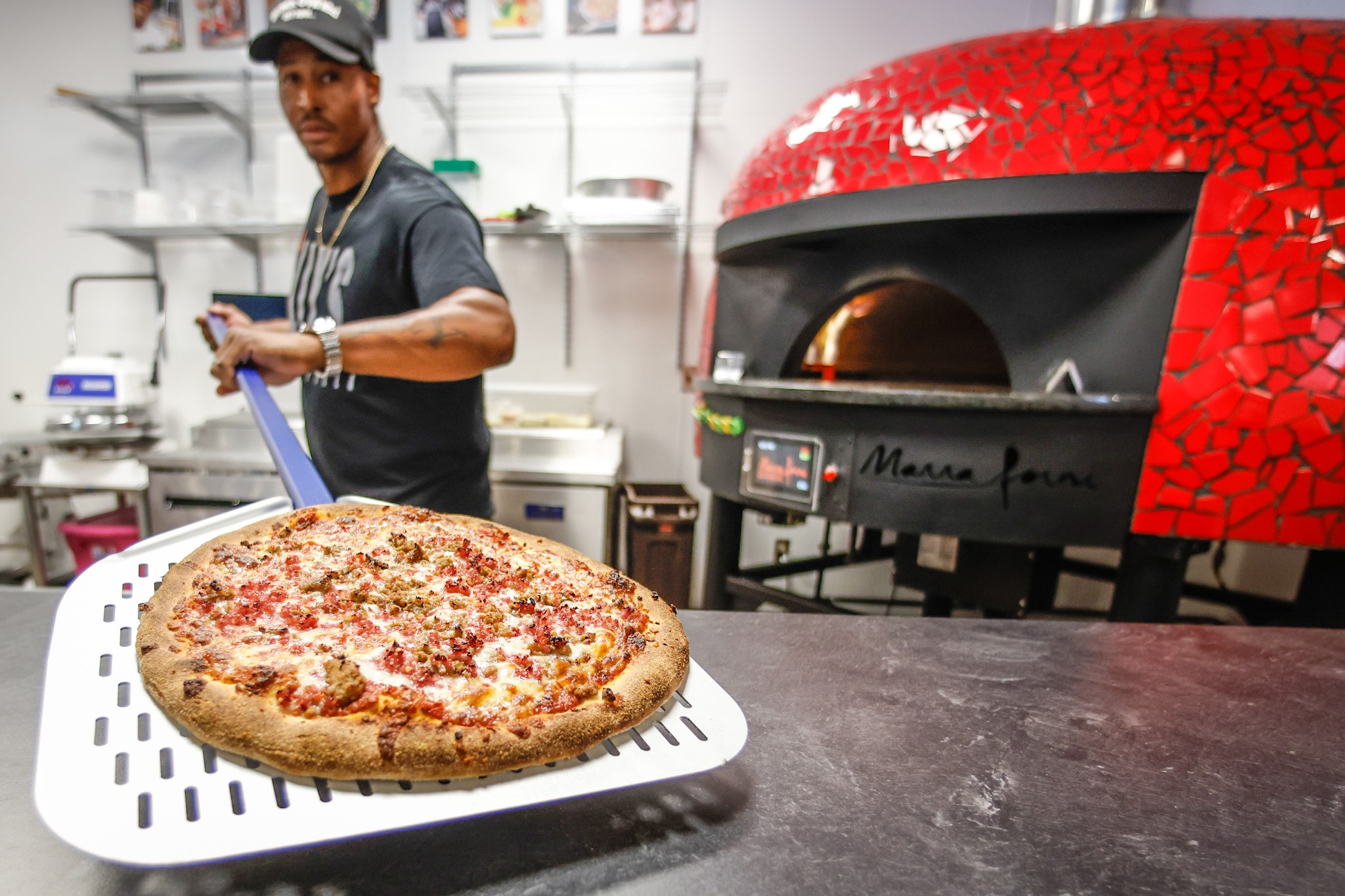 ILLY'S Fire Pizza owner, Robert Gunn pulls out a fresh pizza from the oven. The food hall, located at 1100 West Third St. in Dayton, will open July 25, 2022. JIM NOELKER/STAFF