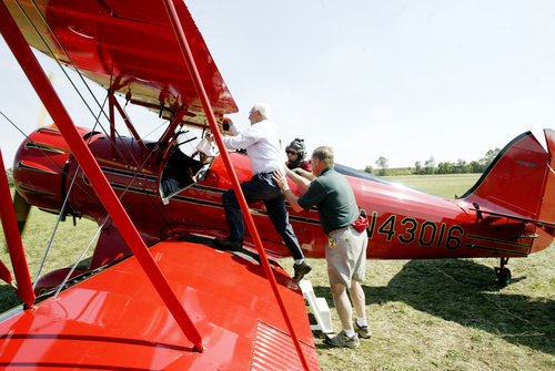 Keith Davison of Hamilton takes a WACO ride with his friend Debbie Roberts during the WACO Homecoming Fly-In in Troy on Sept. 21. The three days event is to welcome WACO planes to their "home" Troy, Ohio, where they were built until the 1940s.