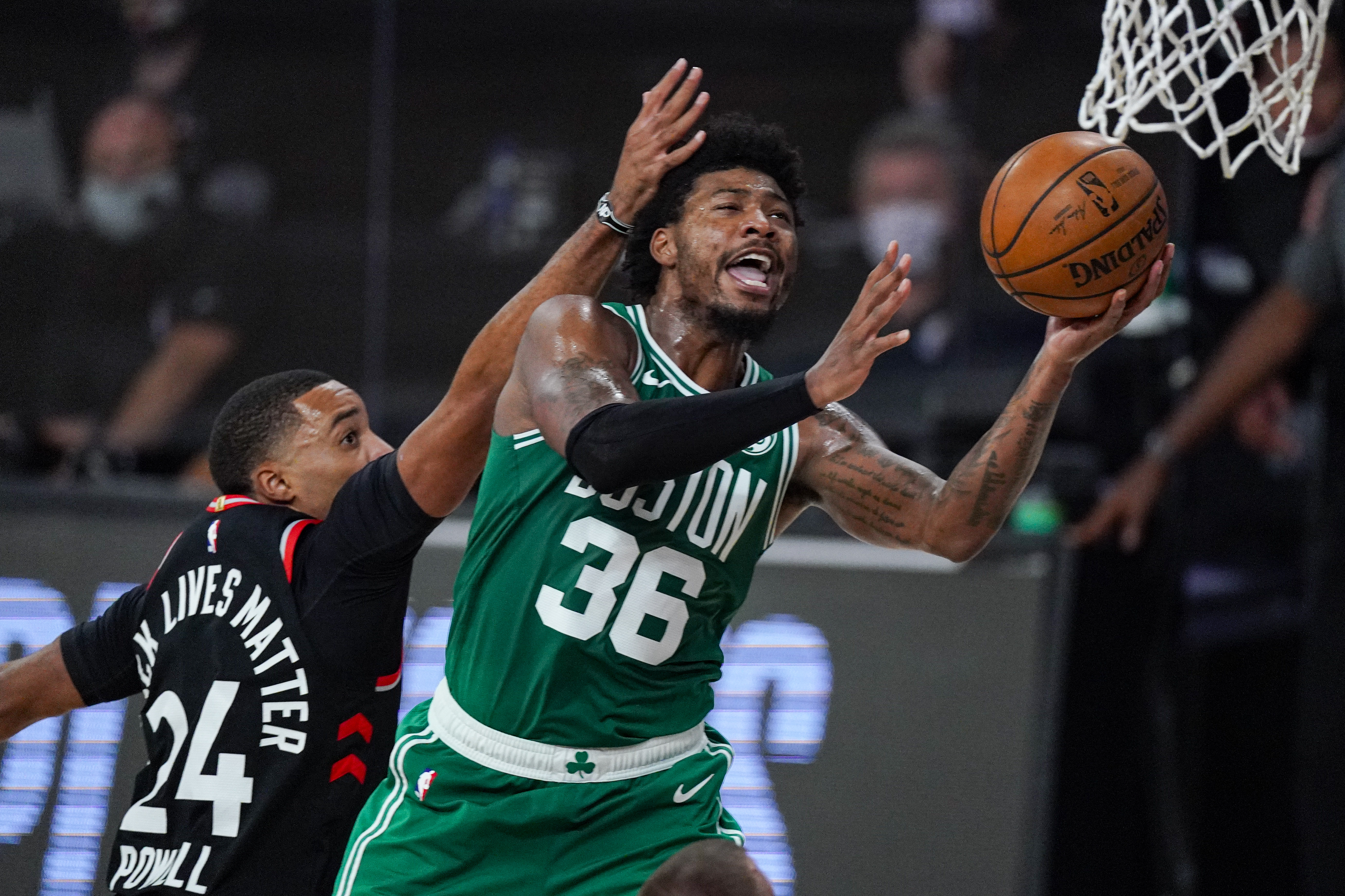 Boston Celtics guard Marcus Smart (36) shoots in front of Toronto Raptors guard Norman Powell (24) during the second half of an NBA conference semifinal playoff basketball game Wednesday, Sept. 9, 2020, in Lake Buena Vista, Fla. (AP Photo/Mark J. Terrill)