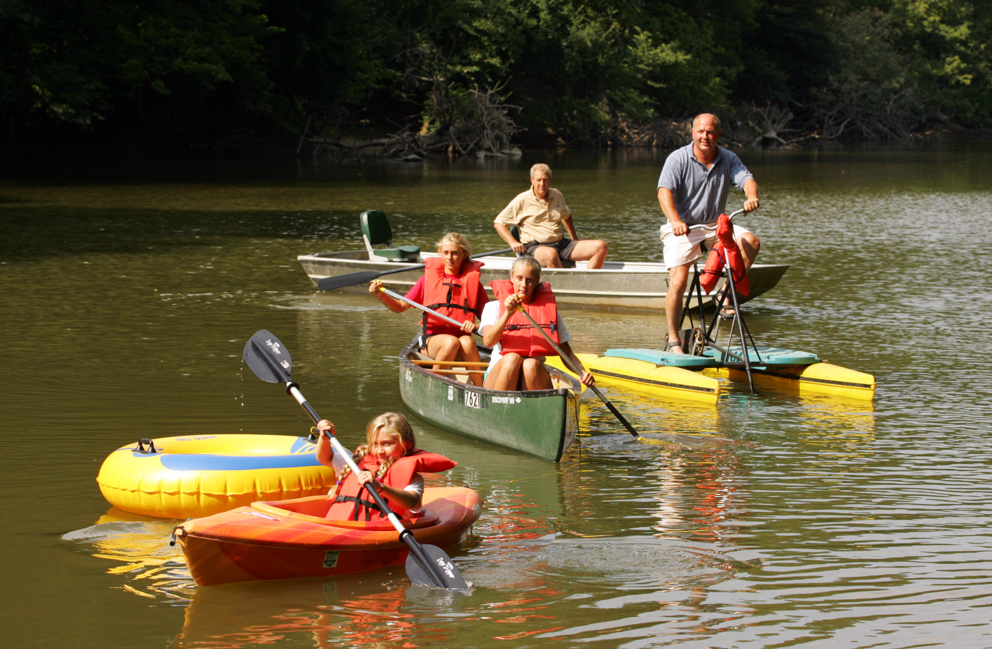 Demonstrating canoes, kayaks, boats, and recreational devices from Great Miami Adventures canoe livery near Tipp City on Ross Road are front to back: Kayte (cq) Jackson, Grace Kauth and Sidney Jackson, Chris Jackson, and Joe Jackson.
Chris Jackson is the owner of the new business that includes a grounds for group events, or camping. Staff Photo by Jim Witmer