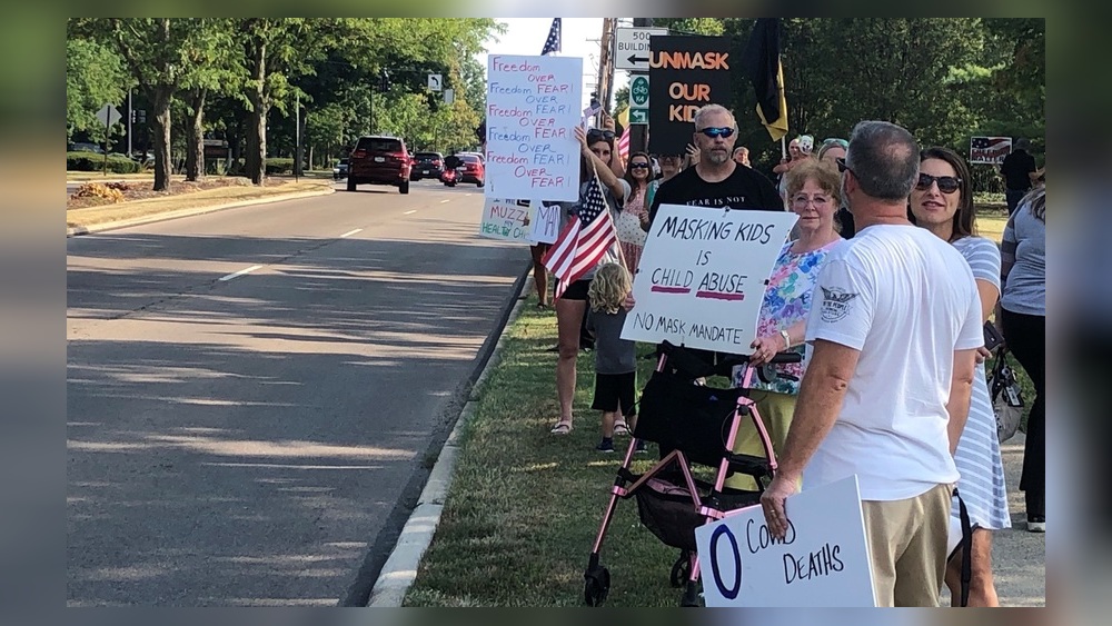 Protesters held signs against a mask mandate for Kettering students before Tuesday evening's school board meeting. Superintendent Scott Inskeep was expected to propose face masks for all students amid increasing COVID-19 cases and quarantines in the district, which started school Aug. 12 with masks optional. Nick Blizzard/Staff