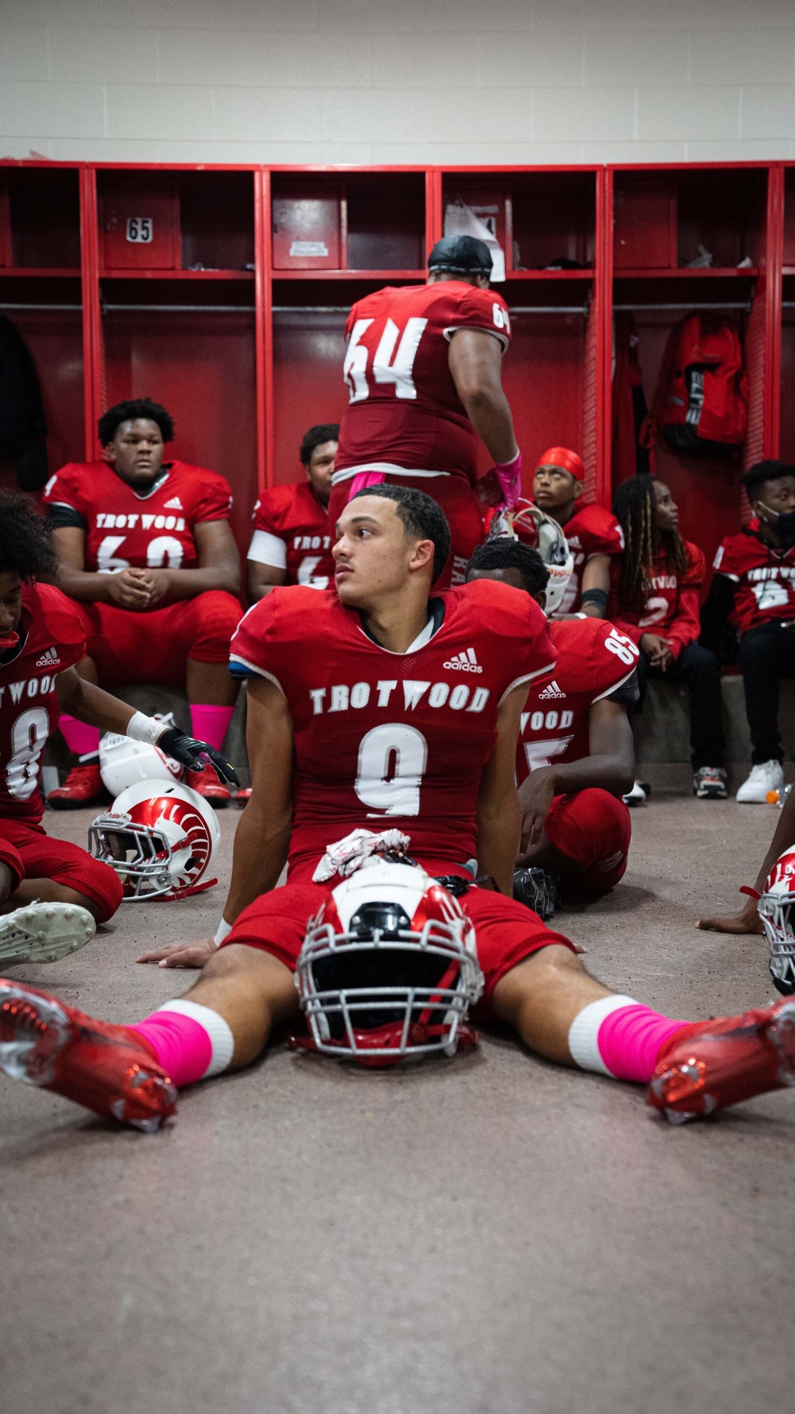 Issiah Evans (No. 9) sits on the dressing room floor before a game last season. Then a sophomore linebacker, he was the leader of the defense and already was drawing scholarship interest from colleges. (Contributed Photo)