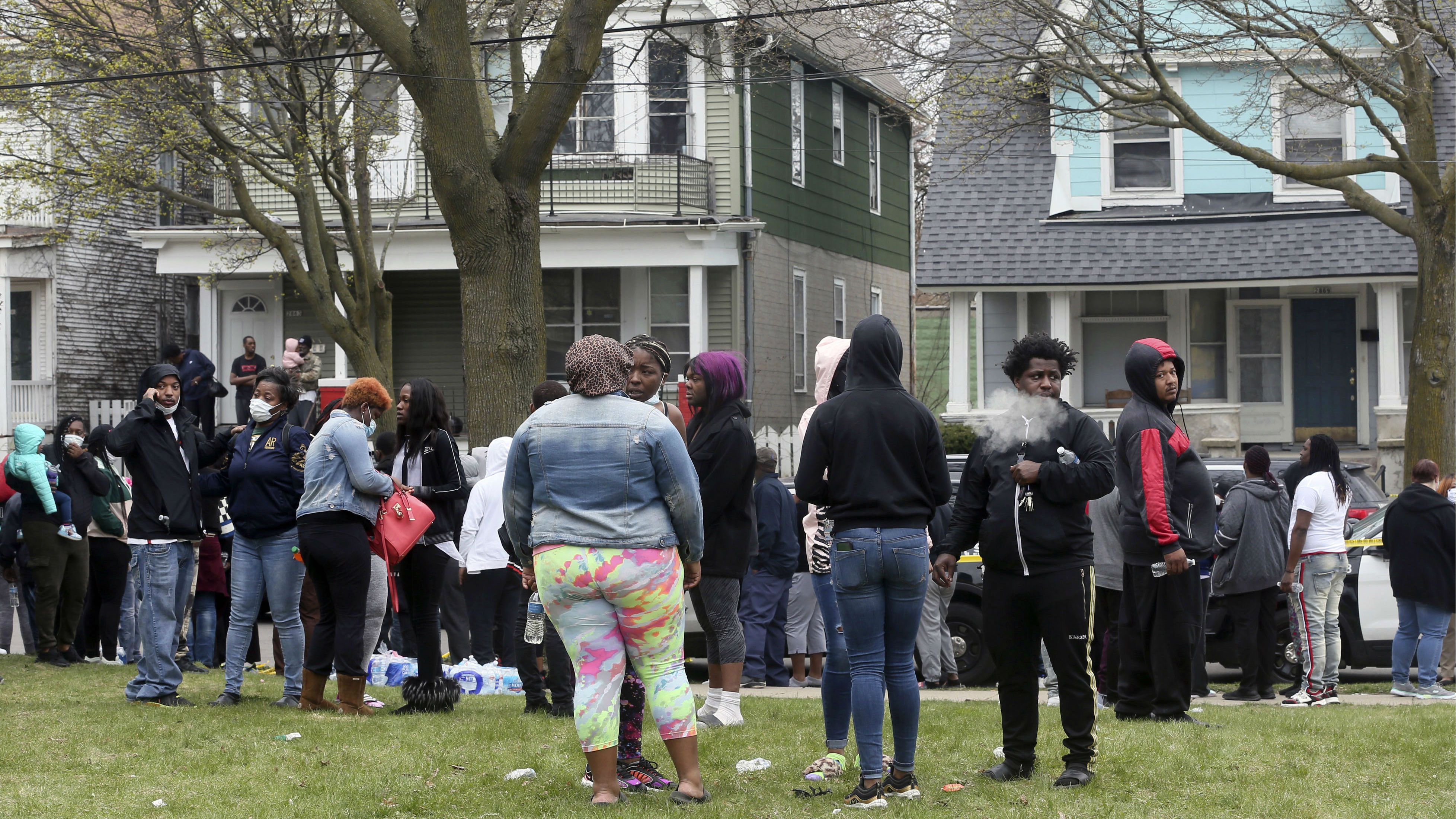 A crowd gathers outside a home where five people were killed in Milwaukee, Wis., Monday, April 27, 2020. Police received a call around 10:30 a.m. Monday from a man who said his family was dead. The caller, identified by family members as Christopher P. Stokes, is suspected in the killings.