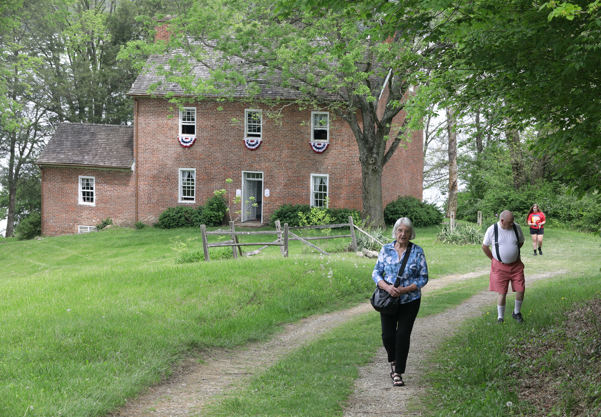 Flossy Hulsizer and her husband, Bob, make their way up the long drive leading to the Crabill Homestead during an open house Saturday, May 14, 2022. The homestead, at Buck Creek State Park is again under the management of the Clark County Historical Society, the organization that originally led the restoration of the 1820s home. BILL LACKEY/STAFF