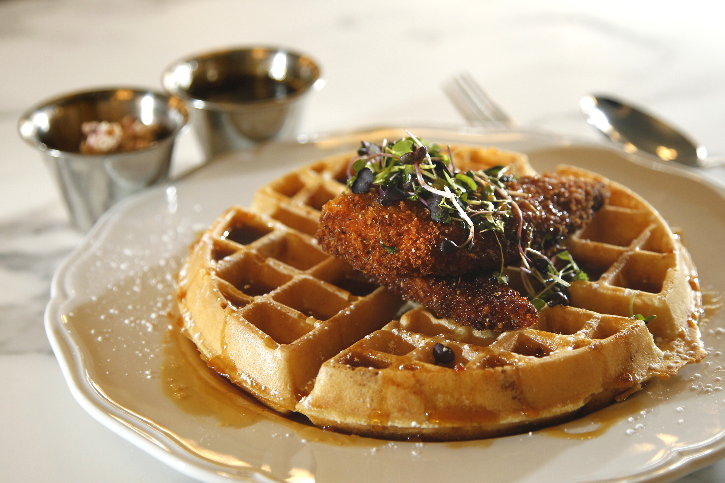 Chicken & Waffles make with Henny Penny's fried chicken and Belgian waffles sprinkled with powdered sugar, and served with blueberry butter and Cajun spiced syrup. It is one of the menu items for new expanded Culp's Cafe at Carillon Historical Park. LISA POWELL / STAFF