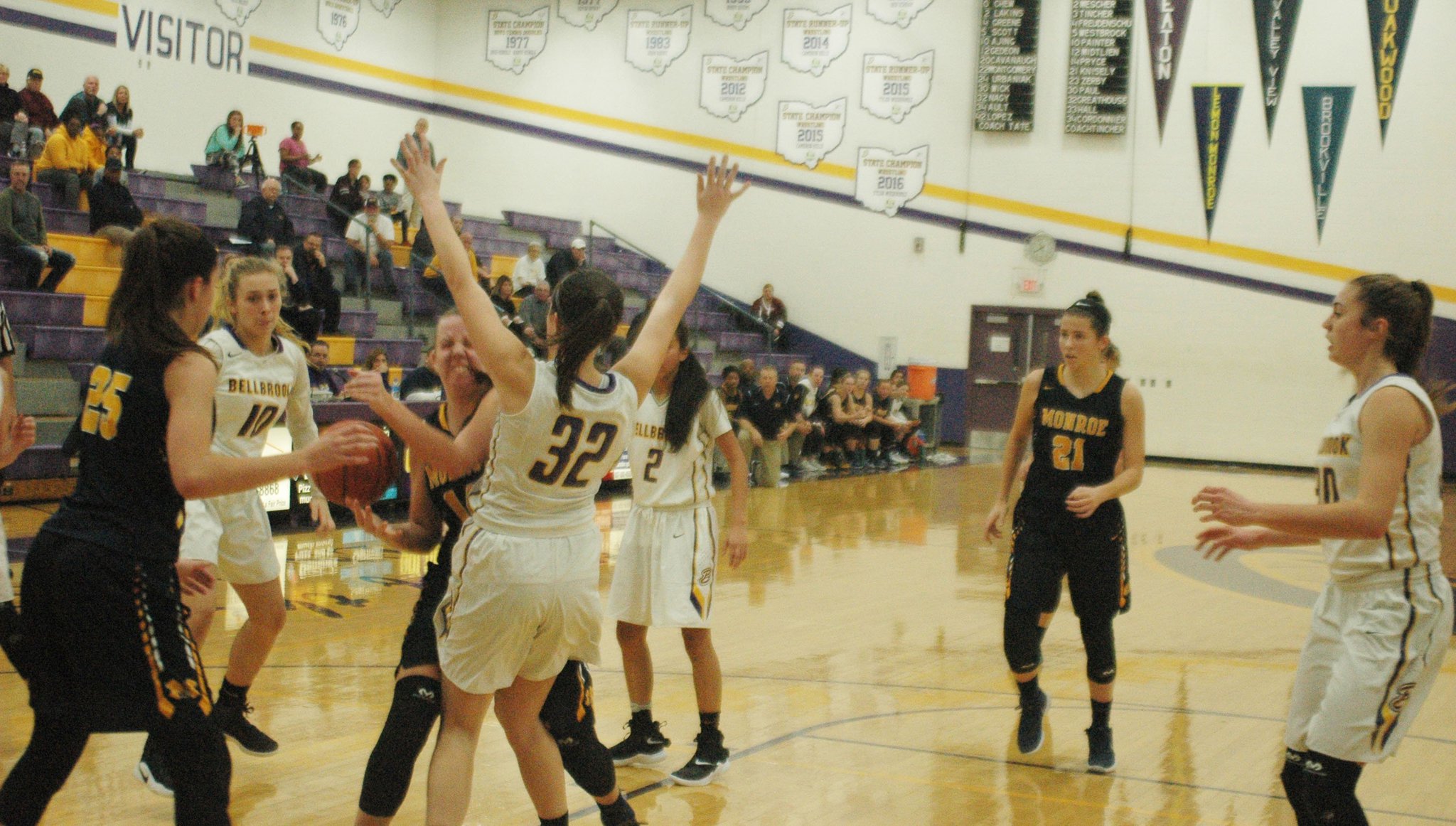 Monroe’s Sophie Sloneker (14) drives into Bellbrook’s Olivia Greathouse (32) during Monday night’s game at Bellbrook. The visiting Hornets won 31-29. RICK CASSANO/STAFF